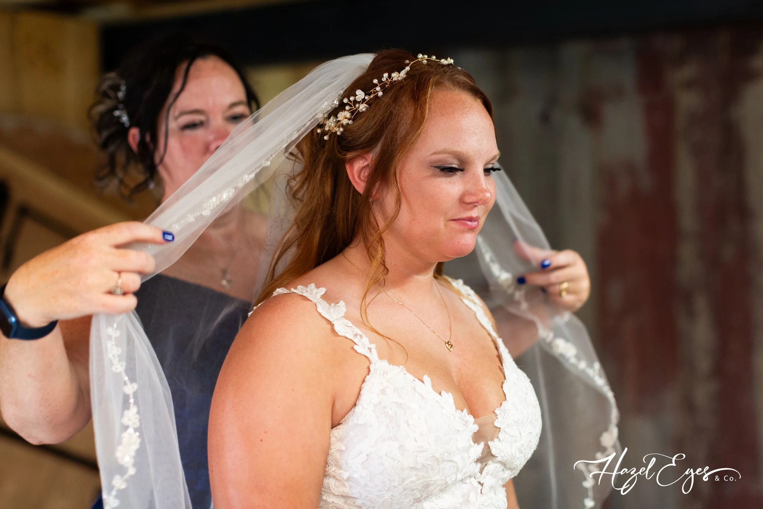 Mom putting veil on bride.