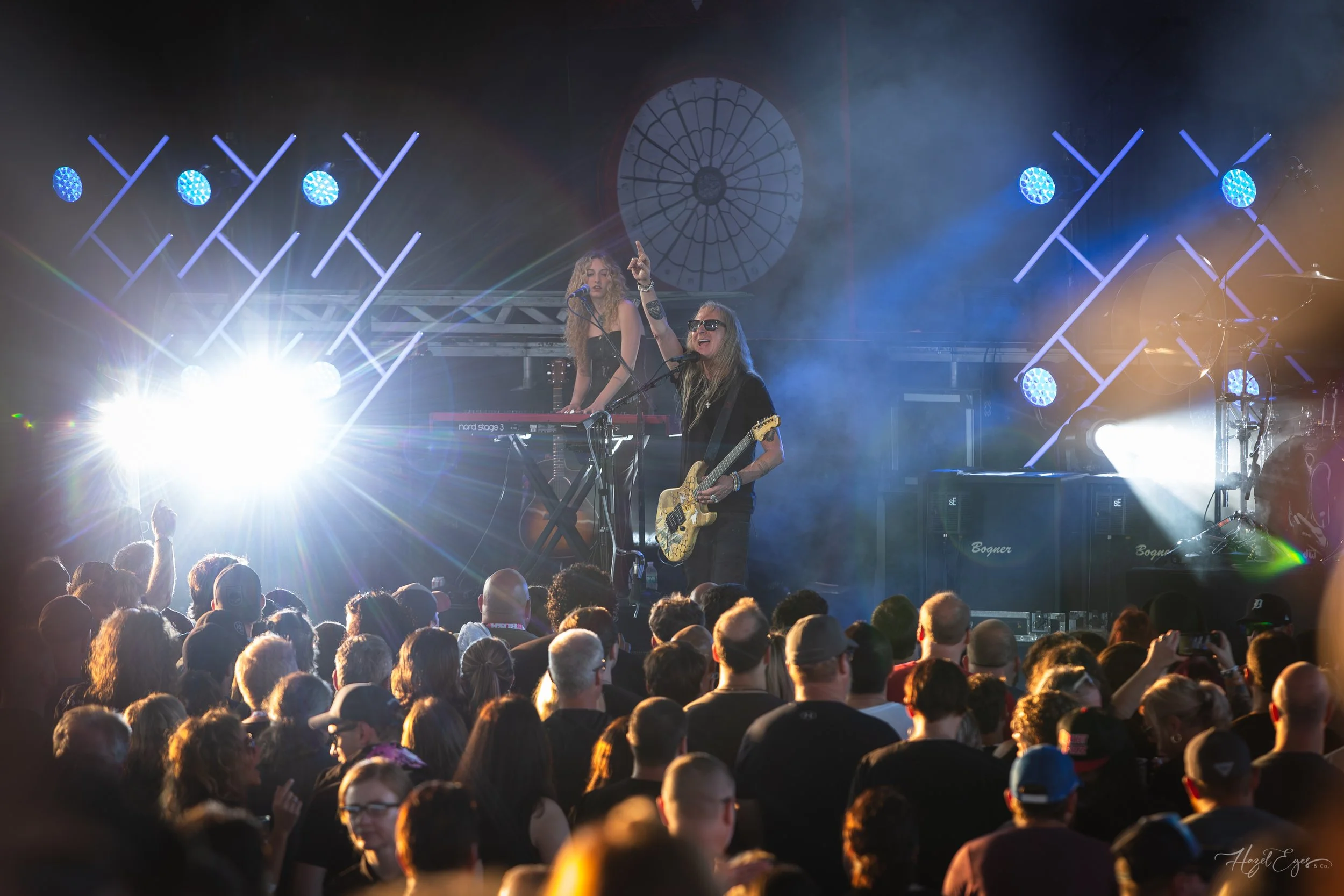 Jerry Cantrell in concert at Michigan Lottery Amphitheatre at Freedom Hill in Sterling Heights, MI on August 16, 2024. Guitarist on stage backlit with bright stage lighting with audience in foreground.