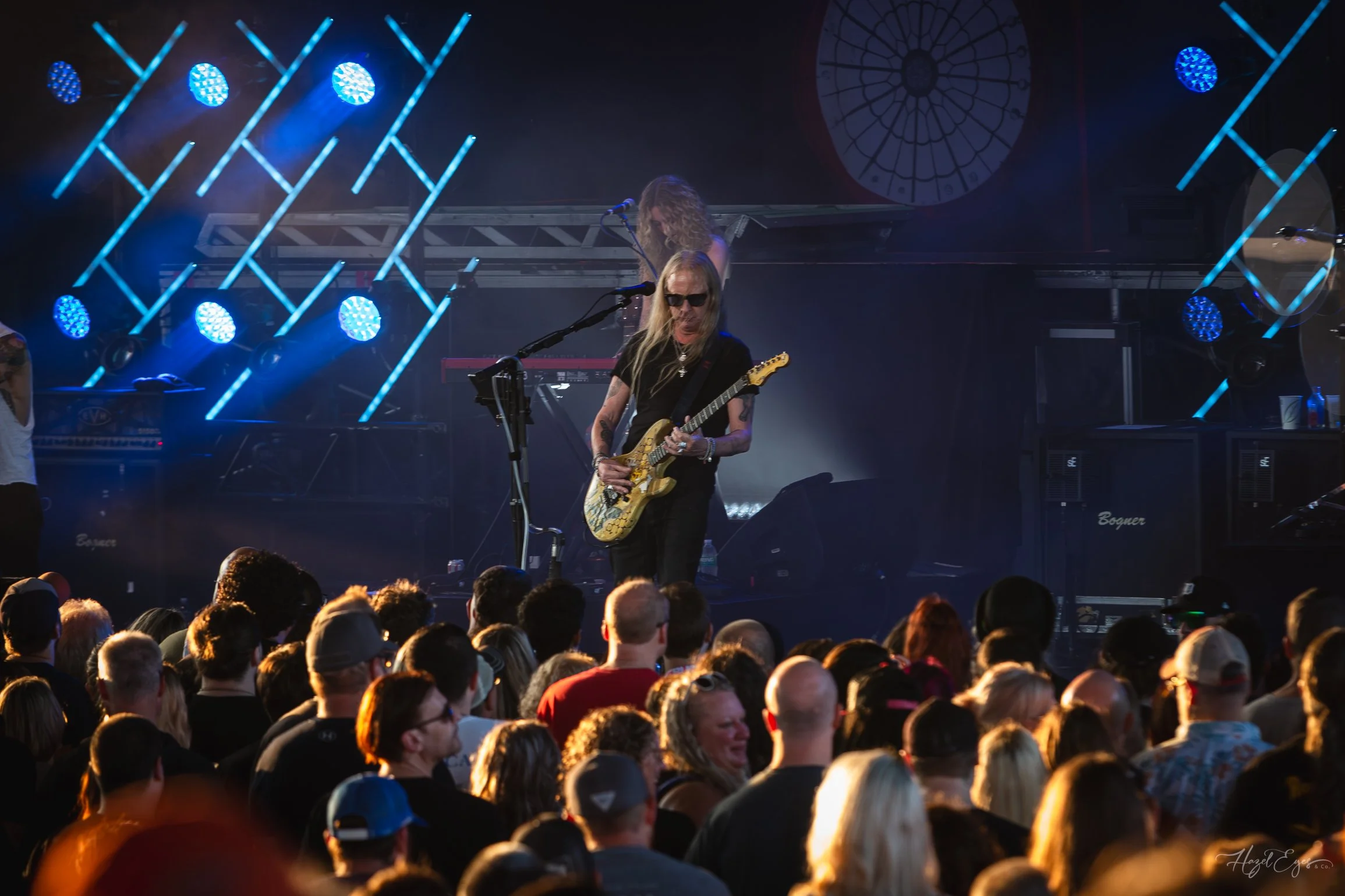 Jerry Cantrell in concert at Michigan Lottery Amphitheatre at Freedom Hill in Sterling Heights, MI on August 16, 2024. Guitarist on stage backlit with bright stage lighting with audience in foreground.