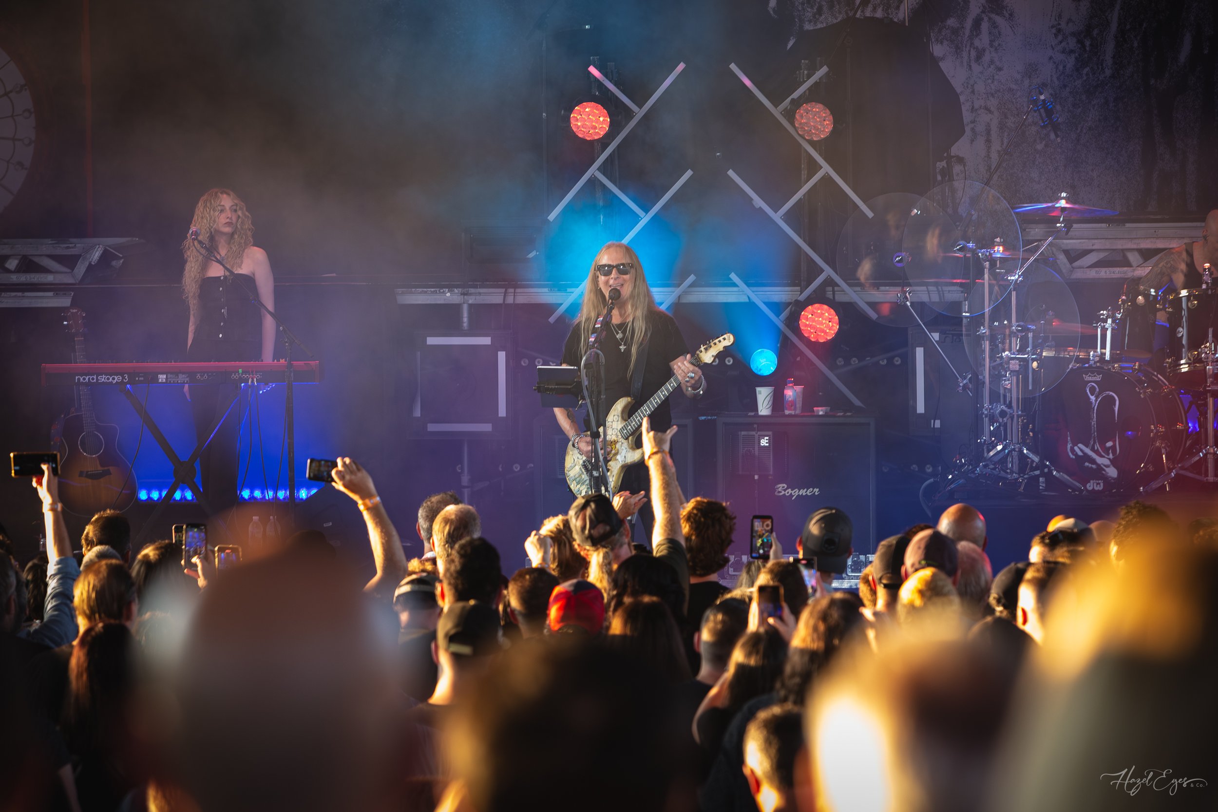Jerry Cantrell in concert at Michigan Lottery Amphitheatre at Freedom Hill in Sterling Heights, MI on August 16, 2024. Guitarist on stage backlit with bright stage lighting with audience in foreground.