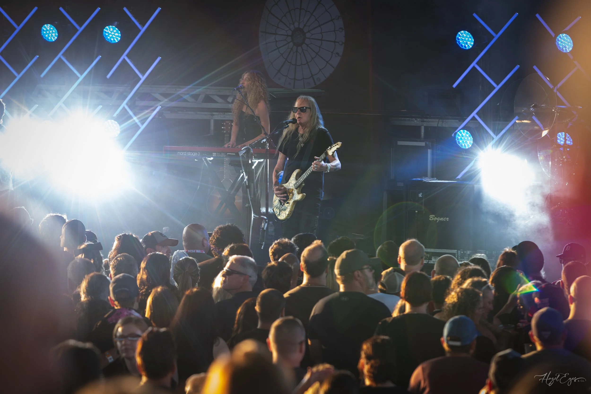 Jerry Cantrell in concert at Michigan Lottery Amphitheatre at Freedom Hill in Sterling Heights, MI on August 16, 2024. Guitarist on stage backlit with bright stage lighting with audience in foreground.