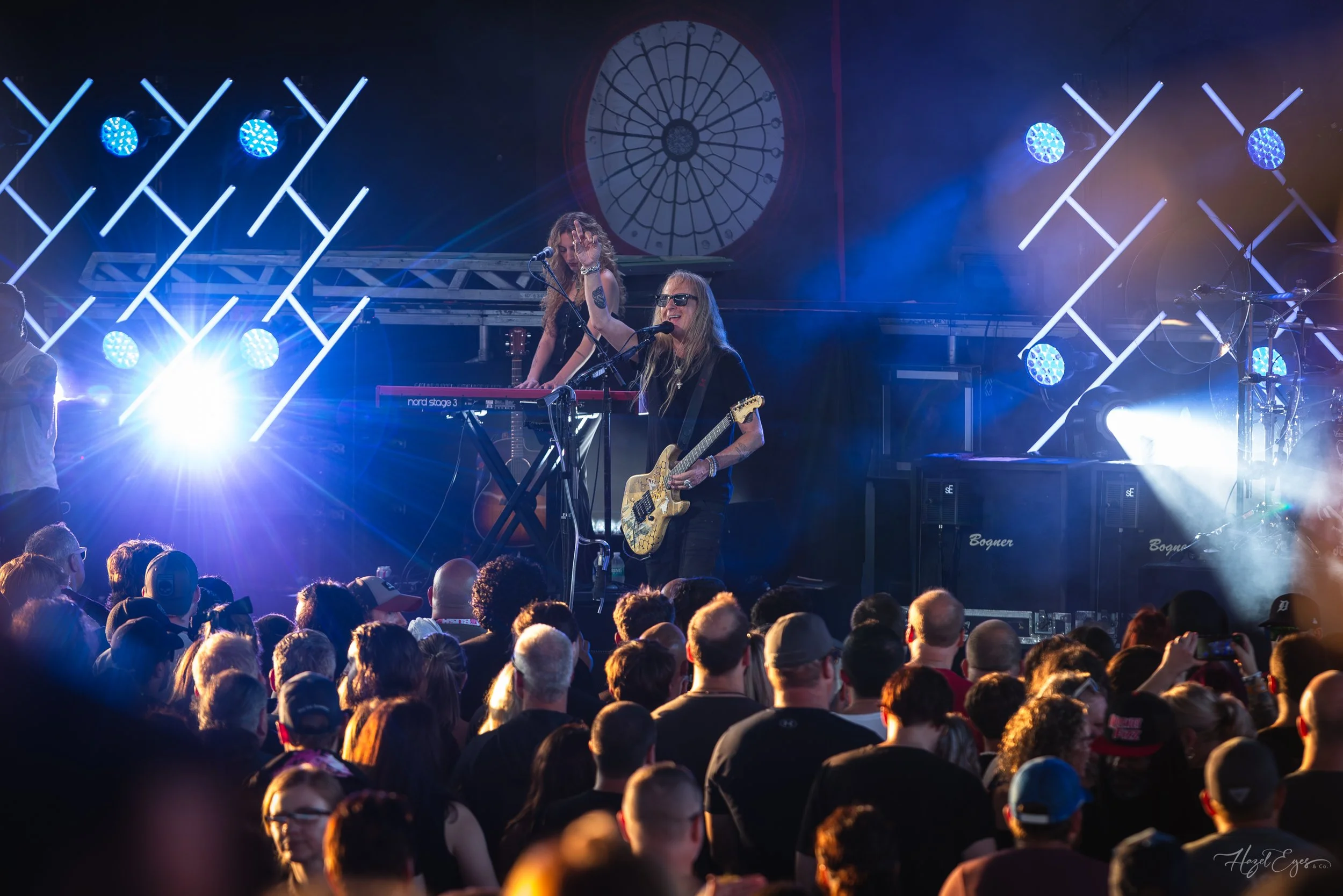 Jerry Cantrell in concert at Michigan Lottery Amphitheatre at Freedom Hill in Sterling Heights, MI on August 16, 2024. Guitarist on stage backlit with bright stage lighting with audience in foreground.