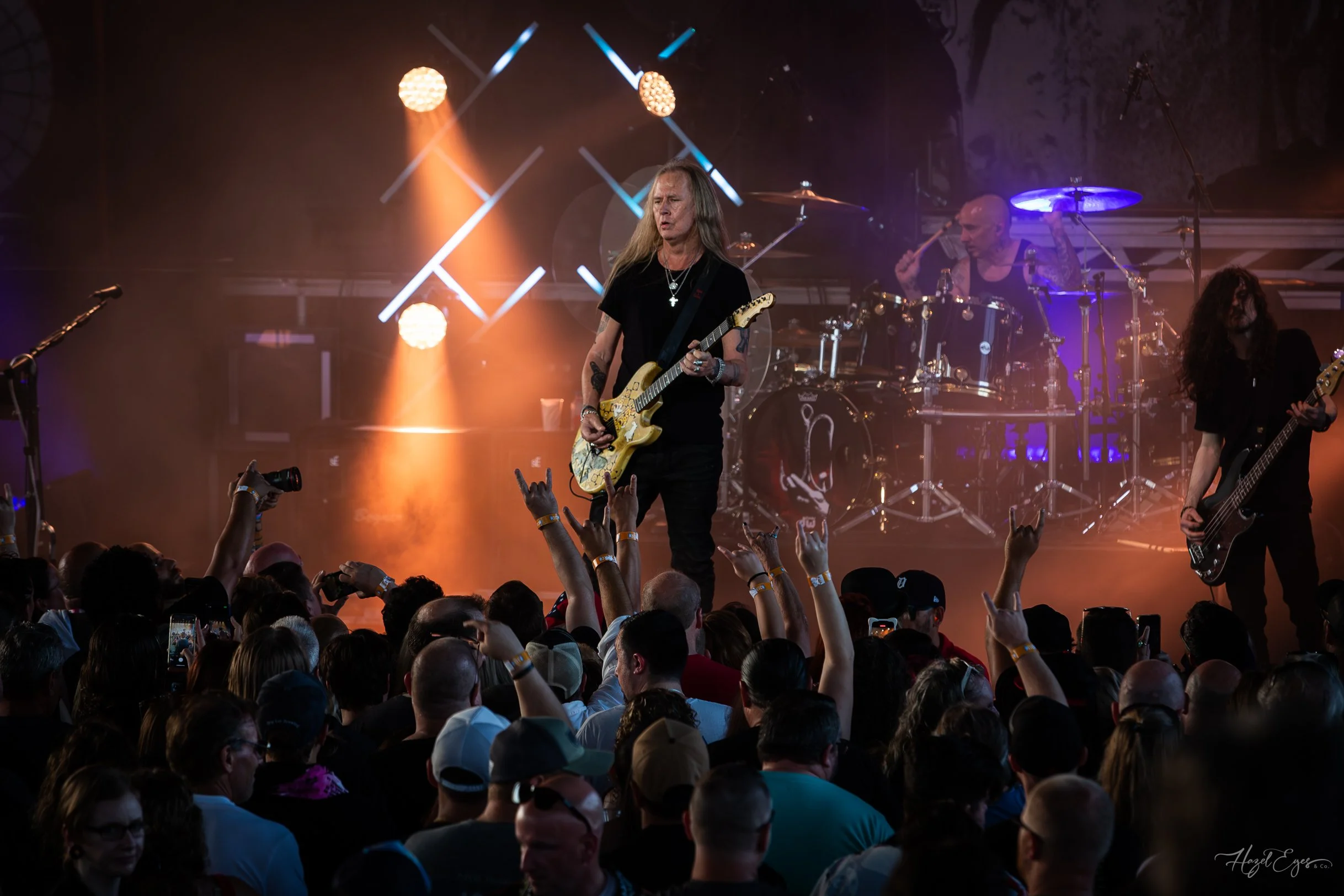 Jerry Cantrell in concert at Michigan Lottery Amphitheatre at Freedom Hill in Sterling Heights, MI on August 16, 2024. Guitarist on stage backlit with bright stage lighting with audience in foreground.