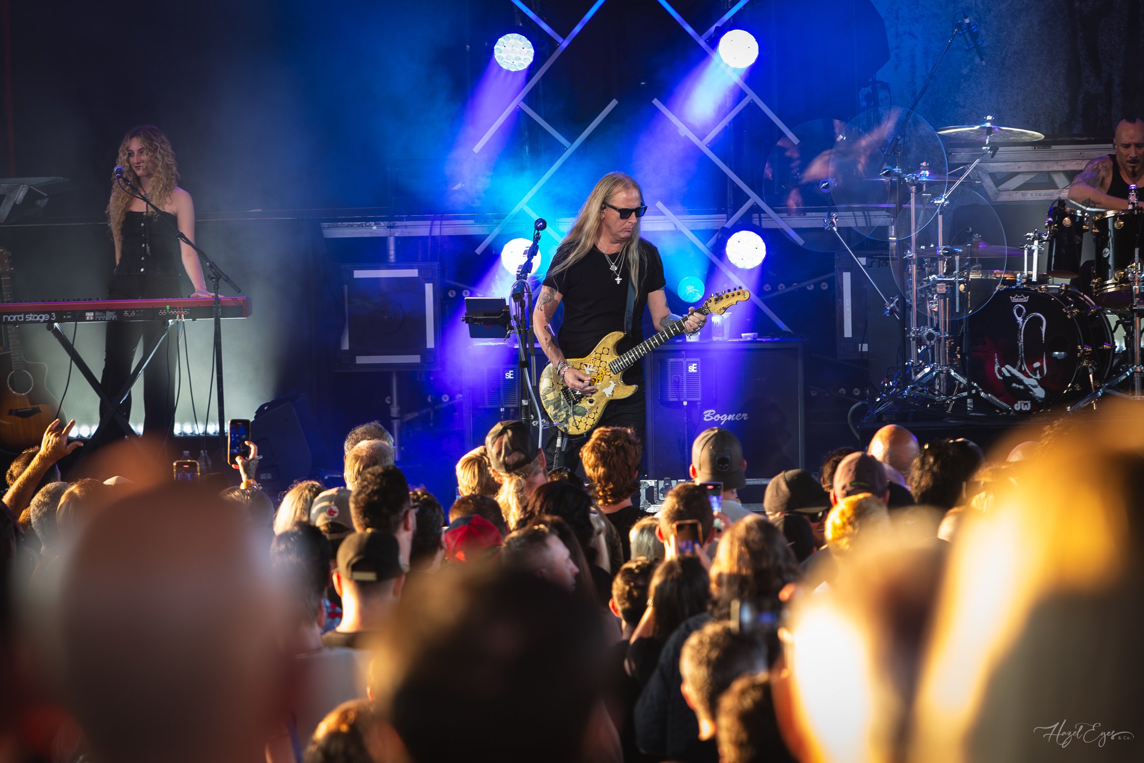 Jerry Cantrell in concert at Michigan Lottery Amphitheatre at Freedom Hill in Sterling Heights, MI on August 16, 2024. Guitarist on stage backlit with bright stage lighting with audience in foreground.