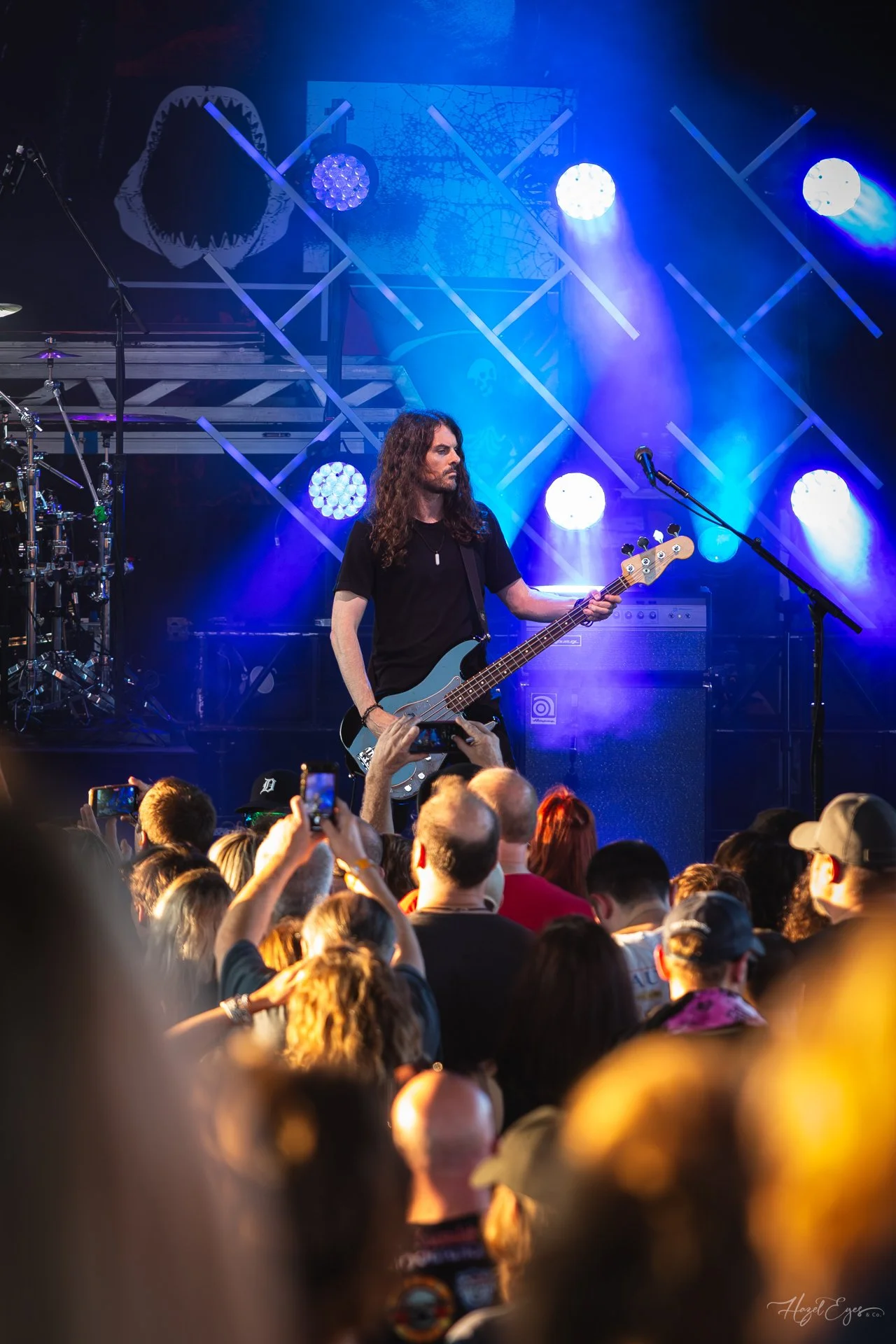 Jerry Cantrell in concert at Michigan Lottery Amphitheatre at Freedom Hill in Sterling Heights, MI on August 16, 2024. Guitarist on stage backlit with bright stage lighting with audience in foreground.