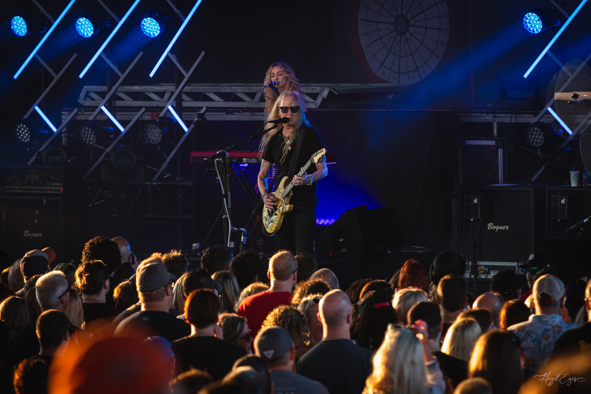 Jerry Cantrell in concert at Michigan Lottery Amphitheatre at Freedom Hill in Sterling Heights, MI on August 16, 2024. Guitarist on stage backlit with bright stage lighting with audience in foreground.