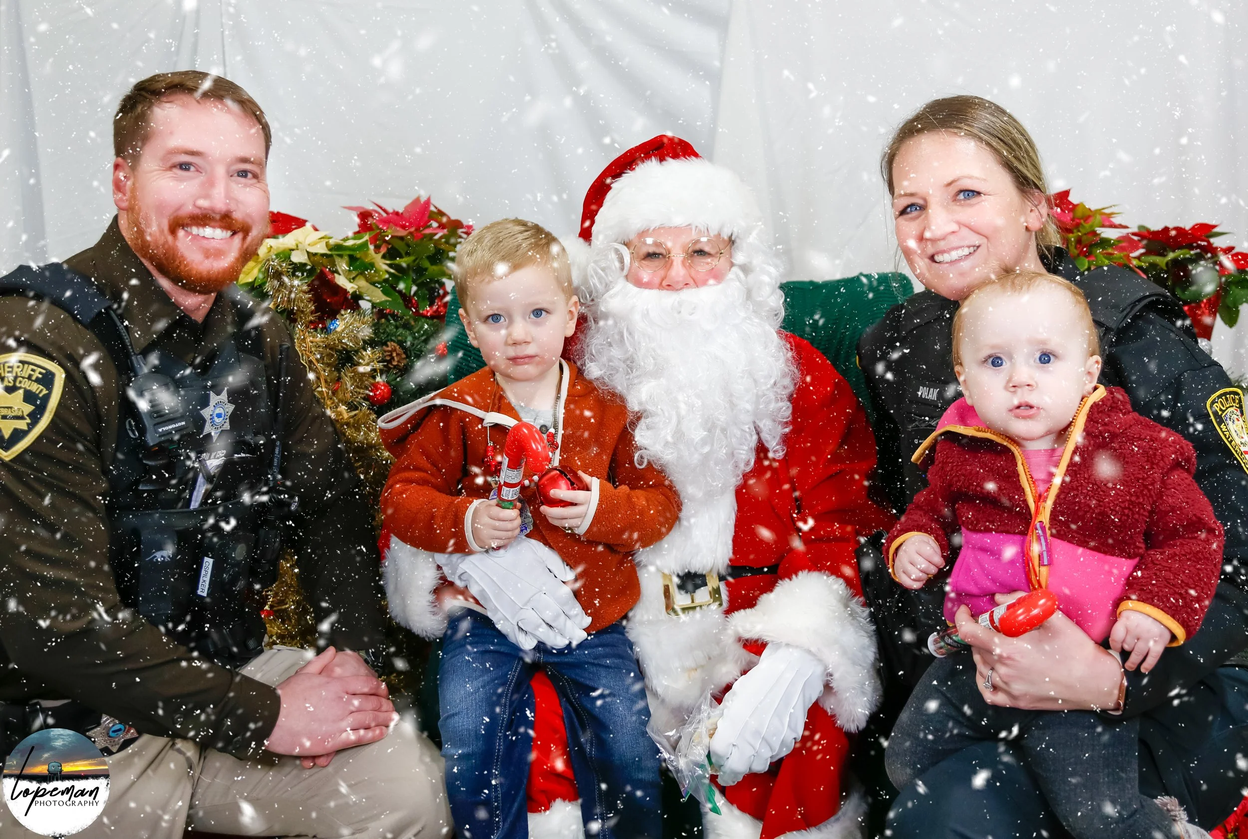 Santa Claus with police officers and children during Christmas event.