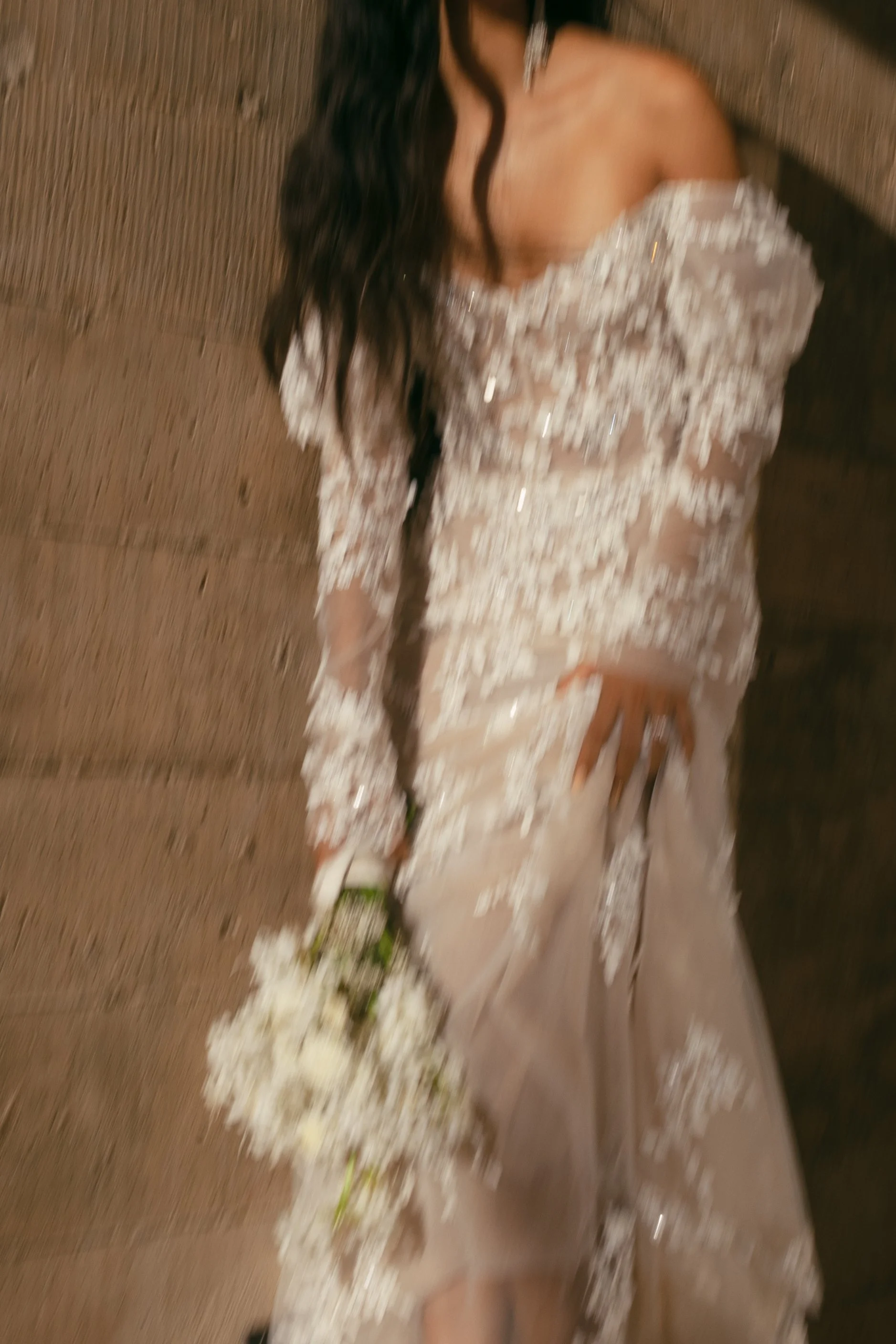 A woman in a wedding dress holding a bouquet of white flowers.