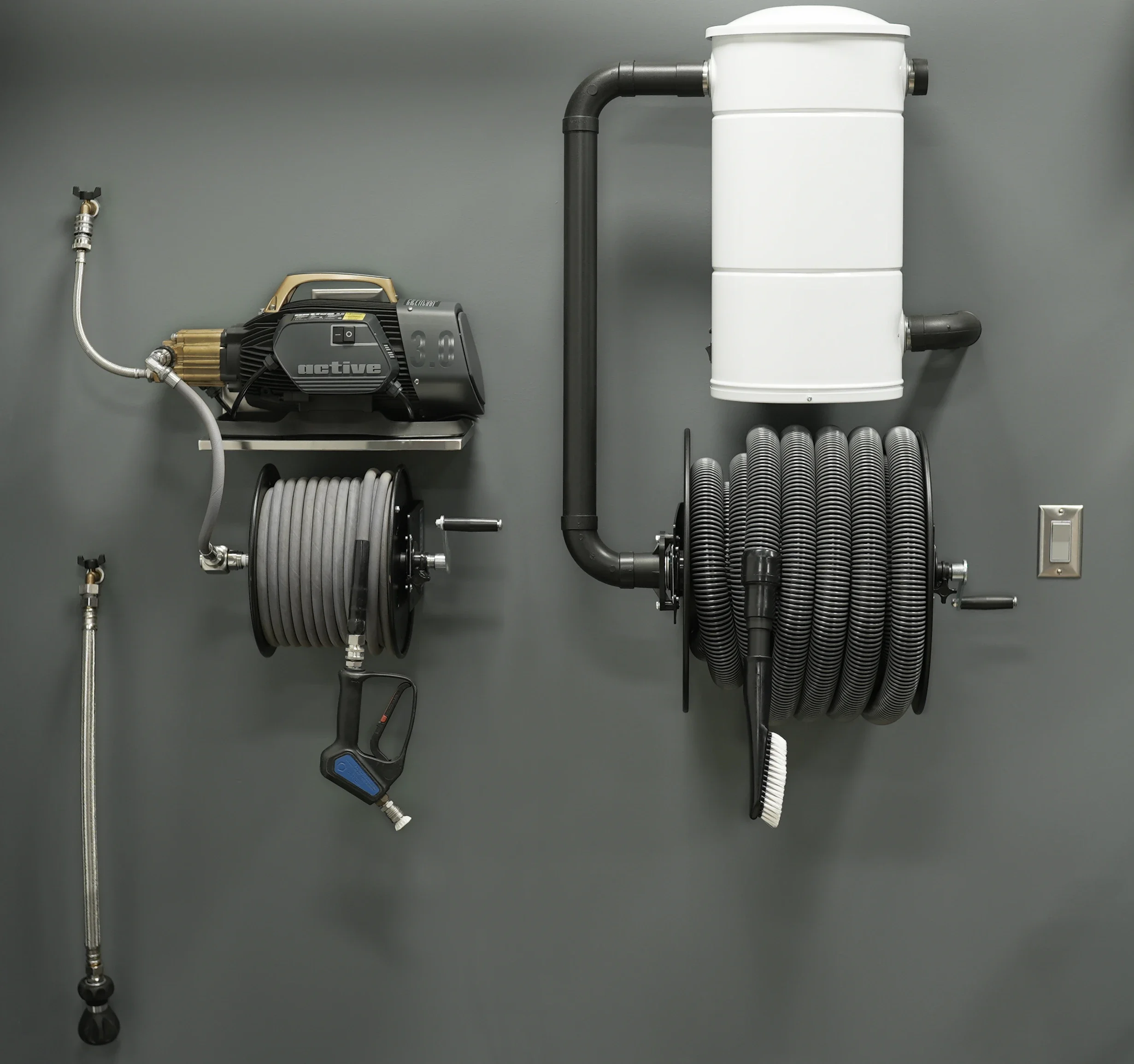 Industrial equipment consisting of a power drill, a white water filter, and assorted pipes and hoses mounted on a gray wall.