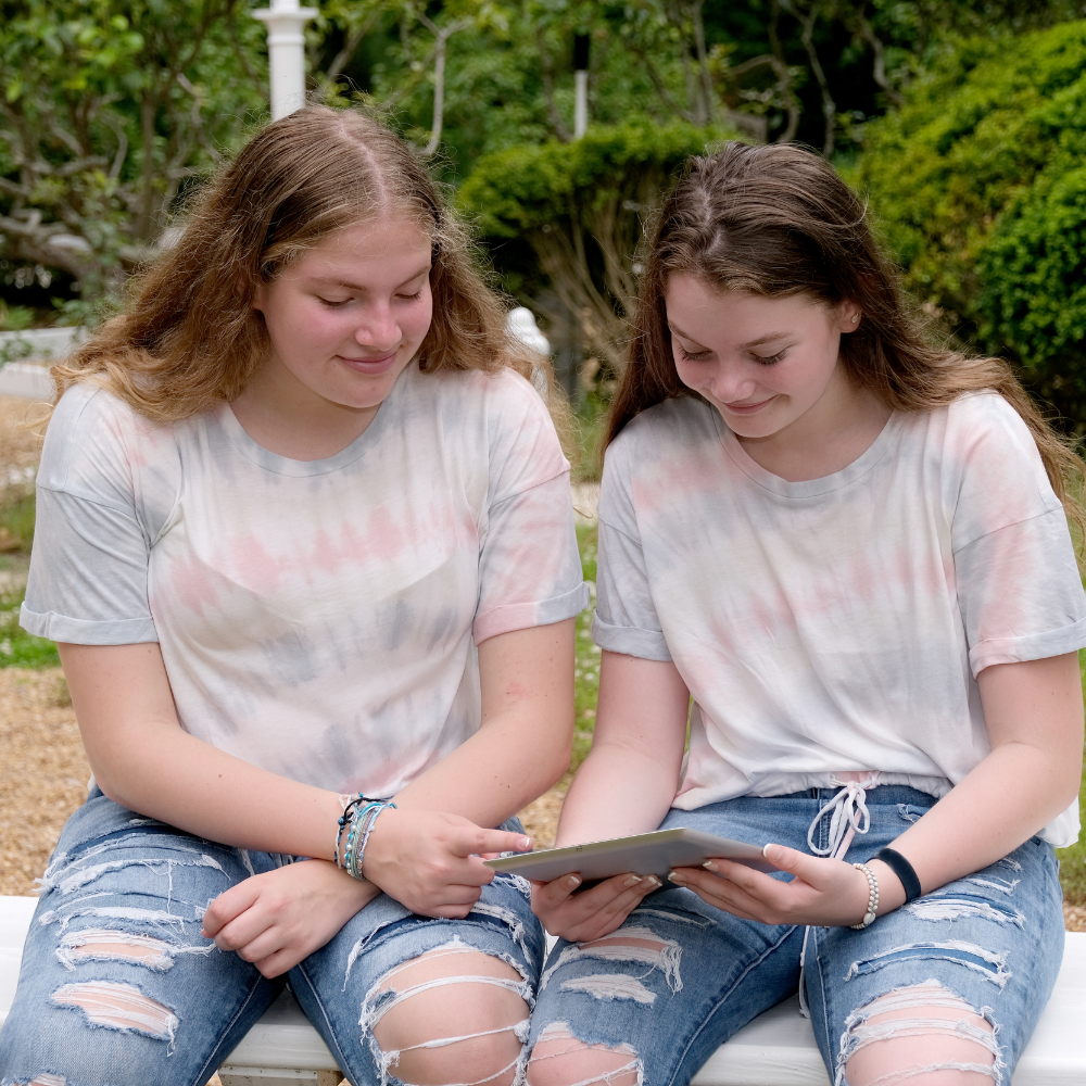 twin girls on their ipad after virtual therapy