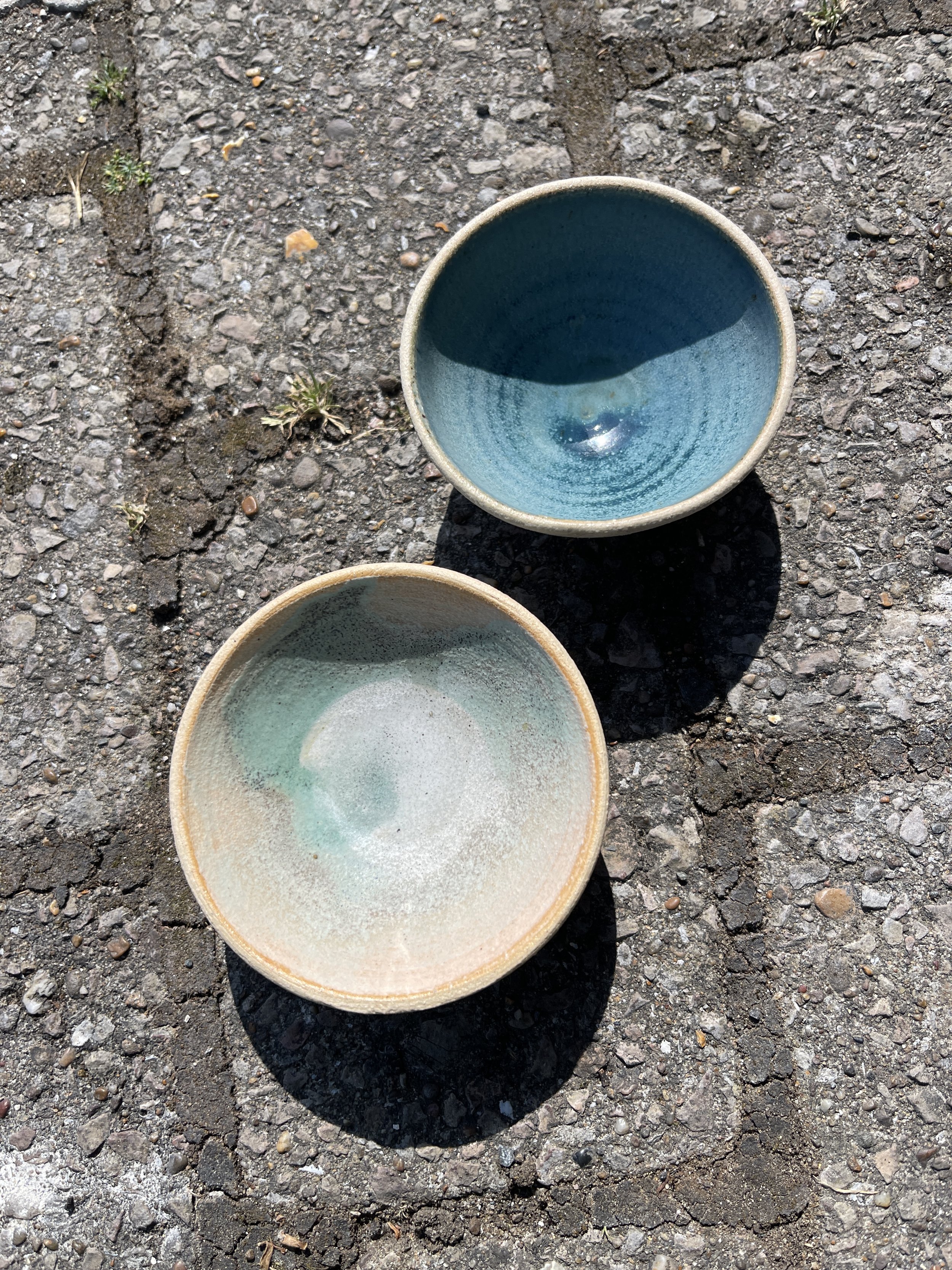 This is an example of leaching. The using matt glazes it is sensible to test with a half-lemon overnight. The white indicates there's been some chemistry with the copper oxide and the acid in the food. Use a transparent on the inside surfaces in c