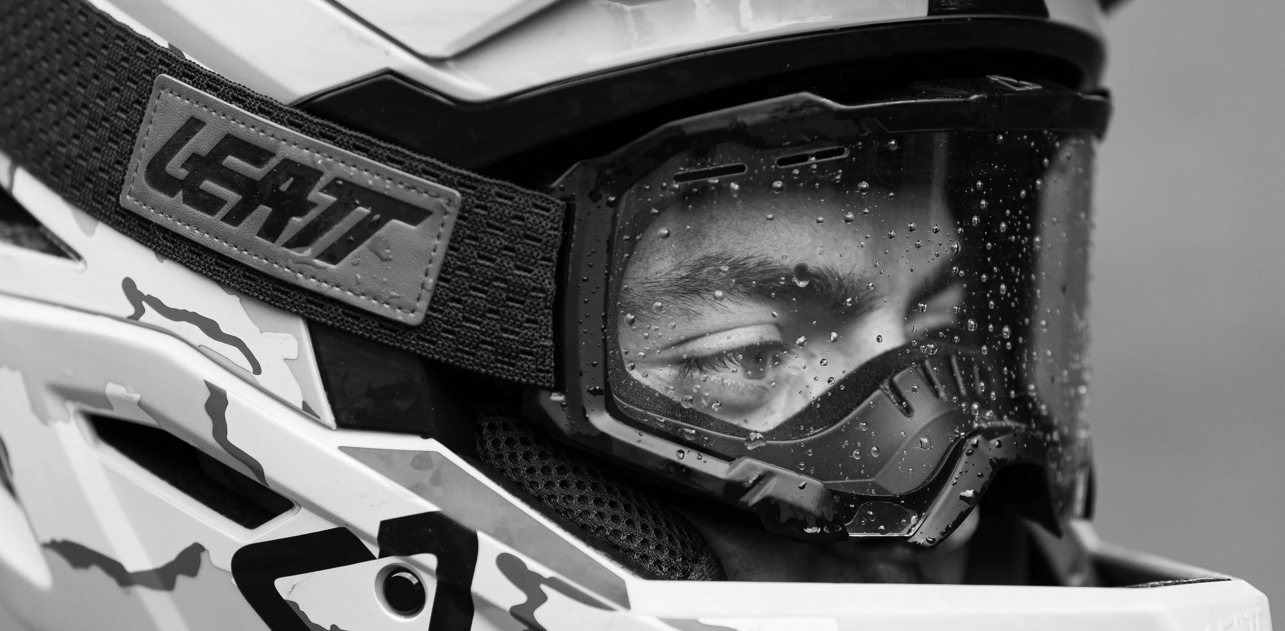 Mountain biker posing with Leatt goggles in the rain at Thunder Mountain Bike Park in Charlemont, Massachusetts. Photographed by Tyler Baker from Tyler Baker Photo.