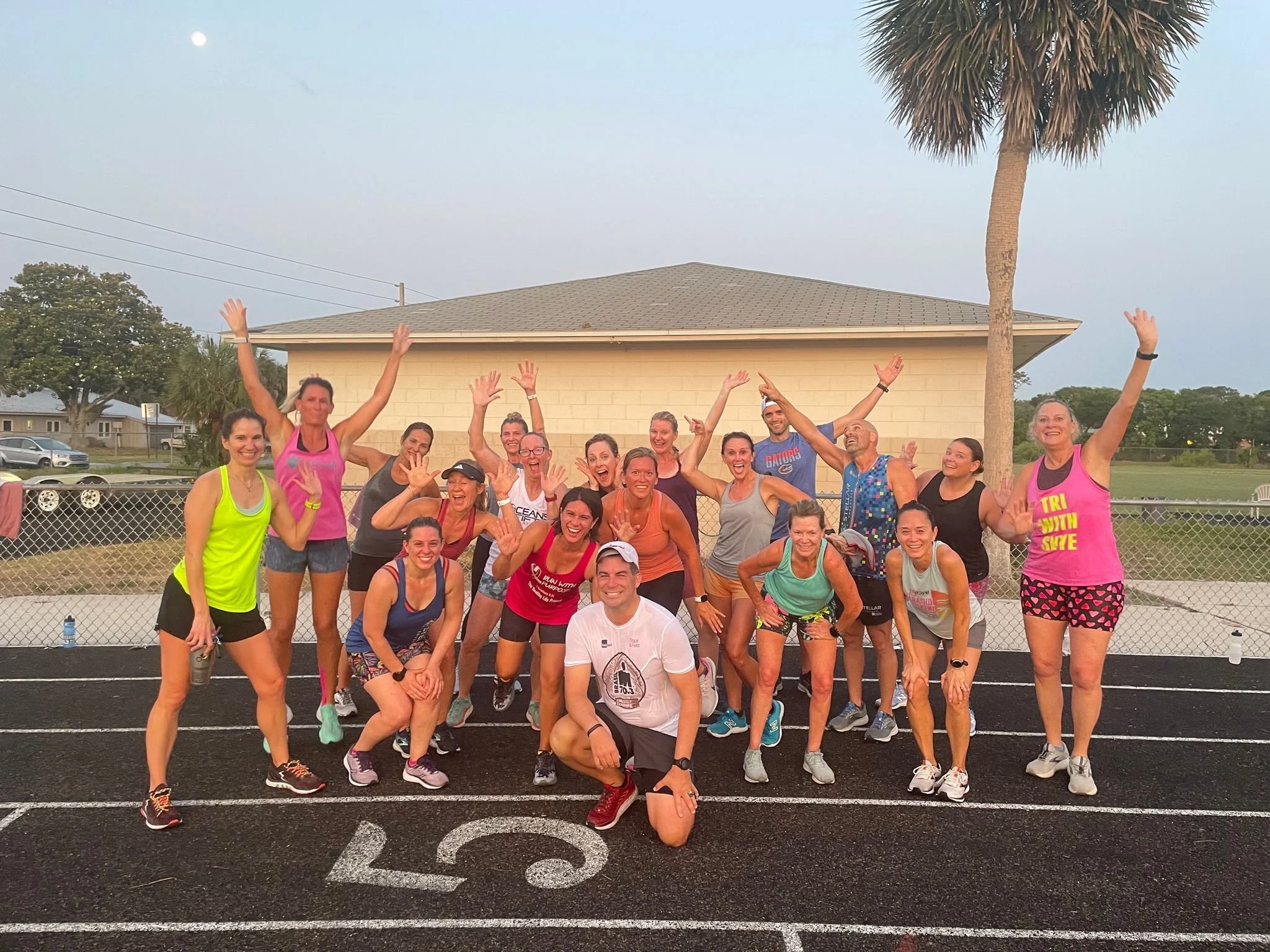 Group poses in workout clothes on a track