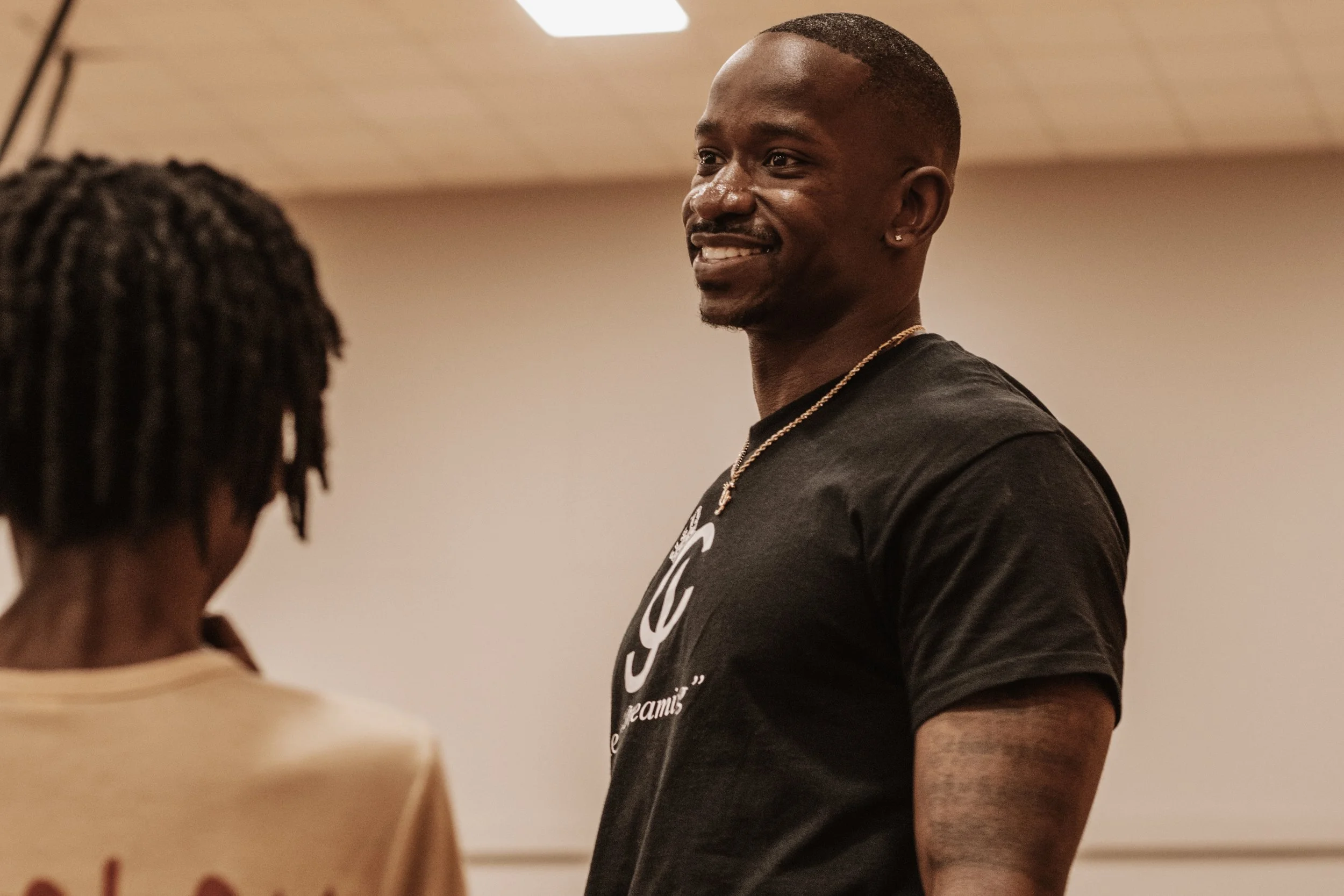 “Charleston Girley smiling while speaking with a student during an indoor event.”