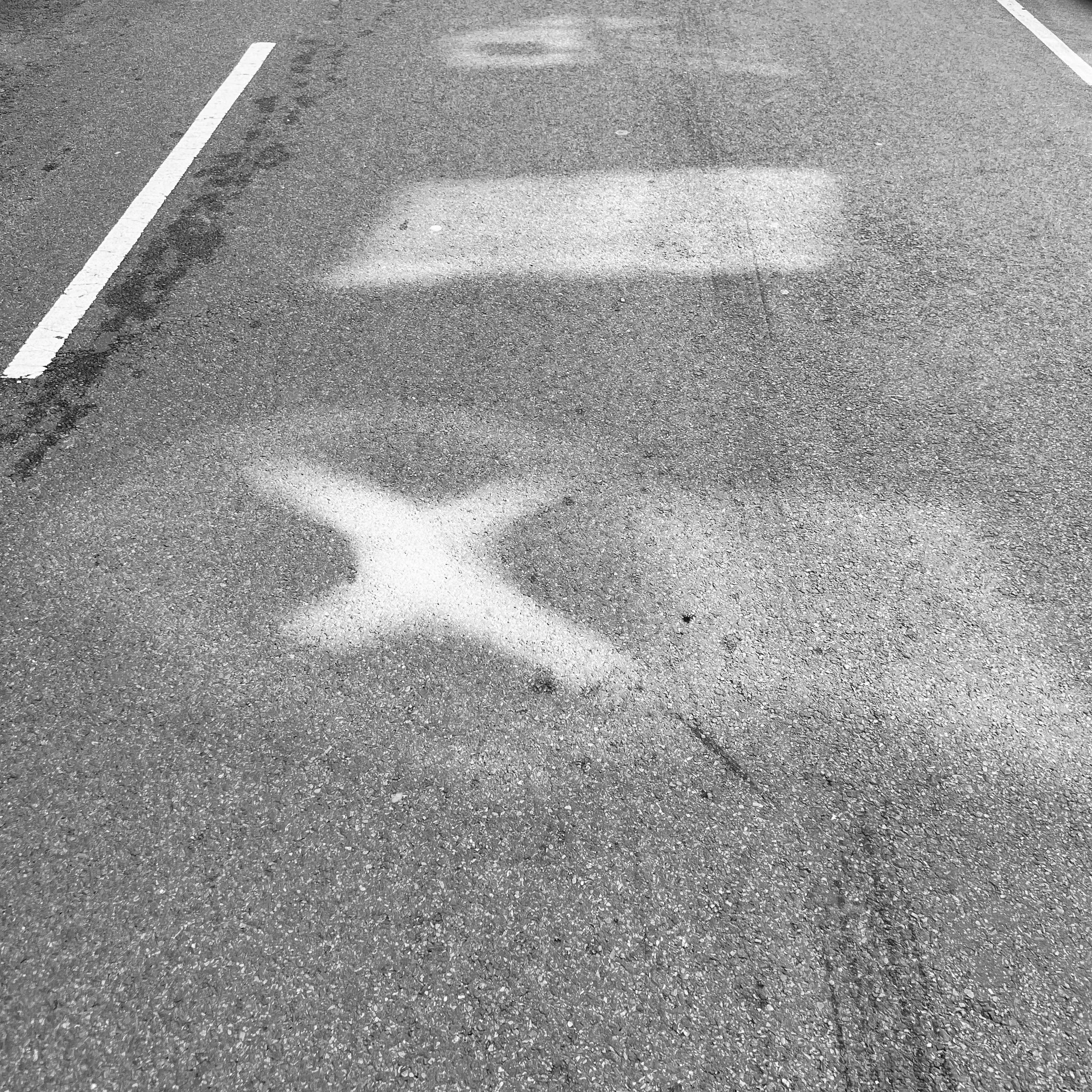 White airplane symbols painted on an asphalt parking lot.