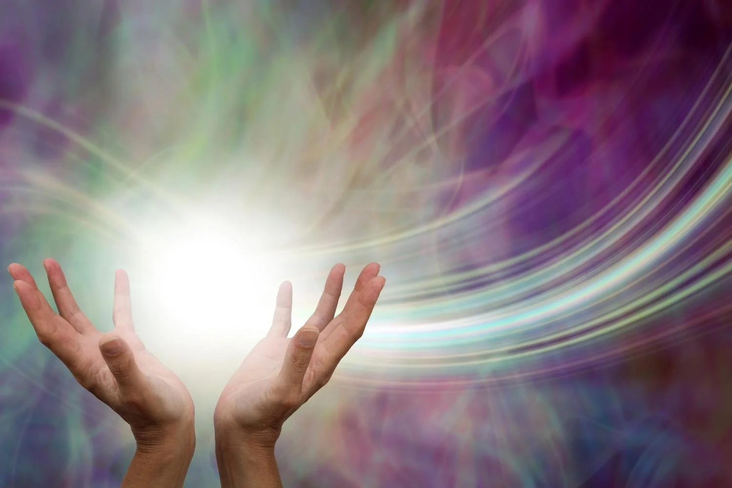 Two hands reaching towards a bright, glowing light source with colorful, swirling, abstract background.