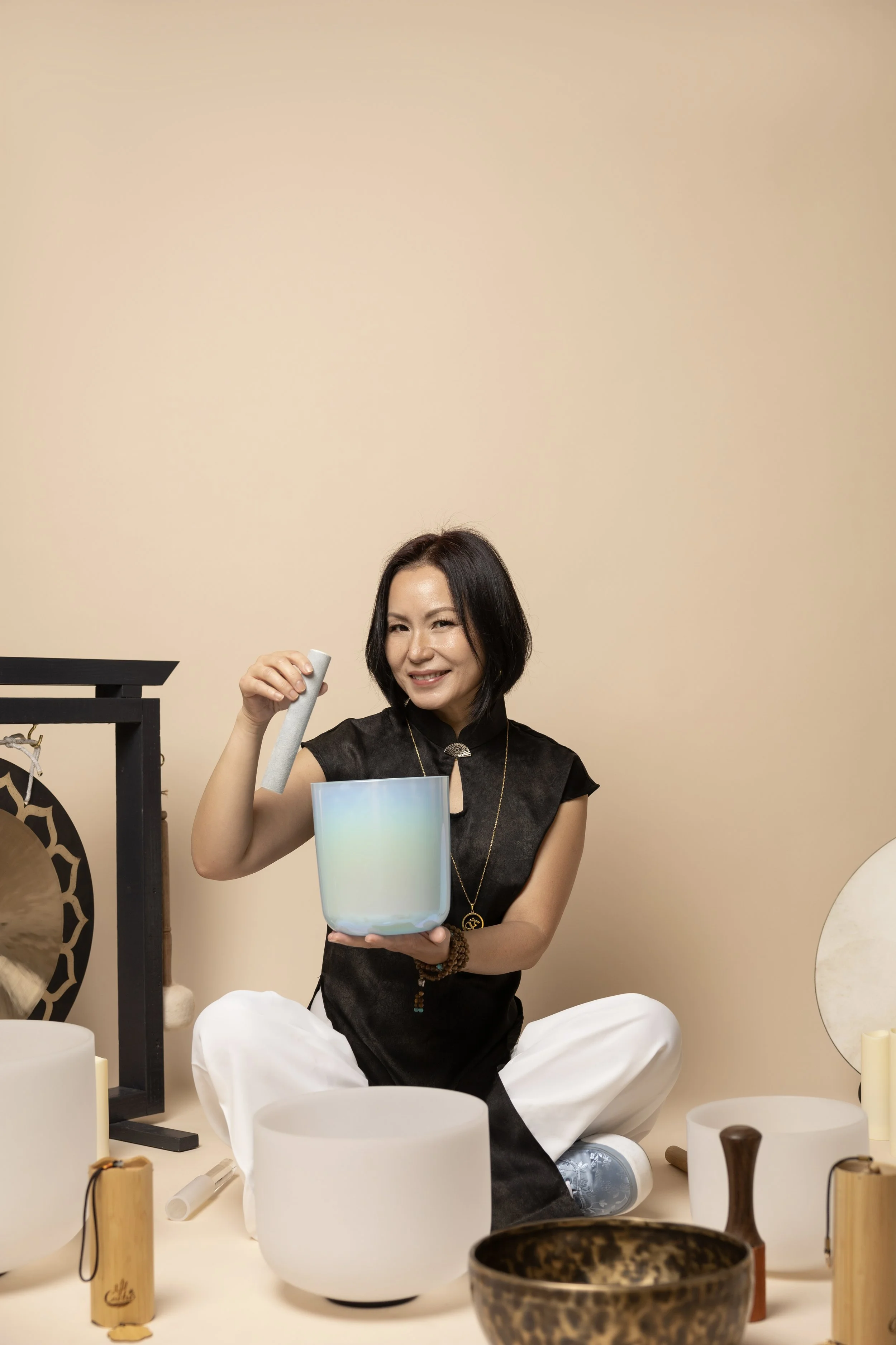 JJ leading a sound healing session with crystal singing bowls in a peaceful healing space