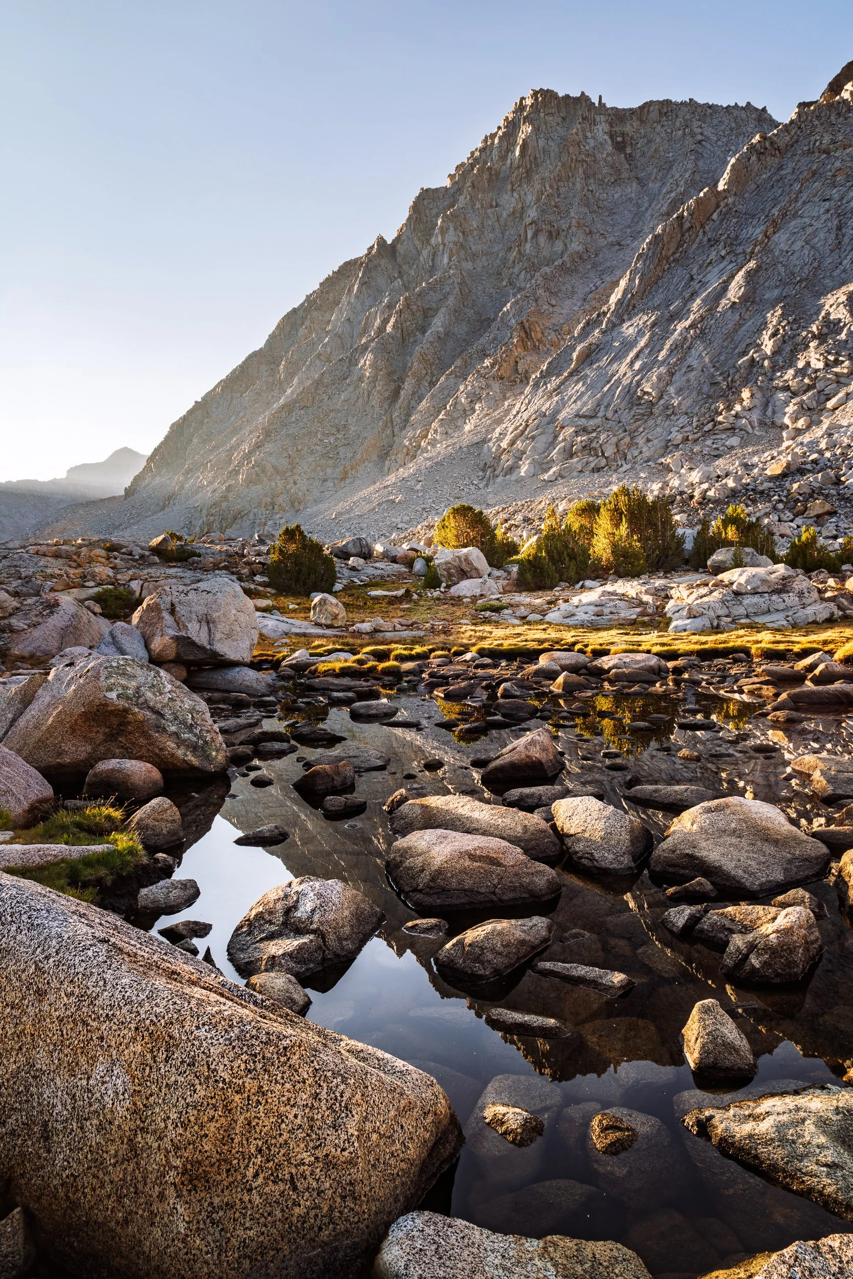 Fractured Reflection
Sunrise on Mount Mendel as seen from the Darwin Bench, Kings Canyon National Park. The rugged, boulder-strewn tarn in the foreground breaks up the morning reflection, serving as a silent reminder of the glacial forces that shaped