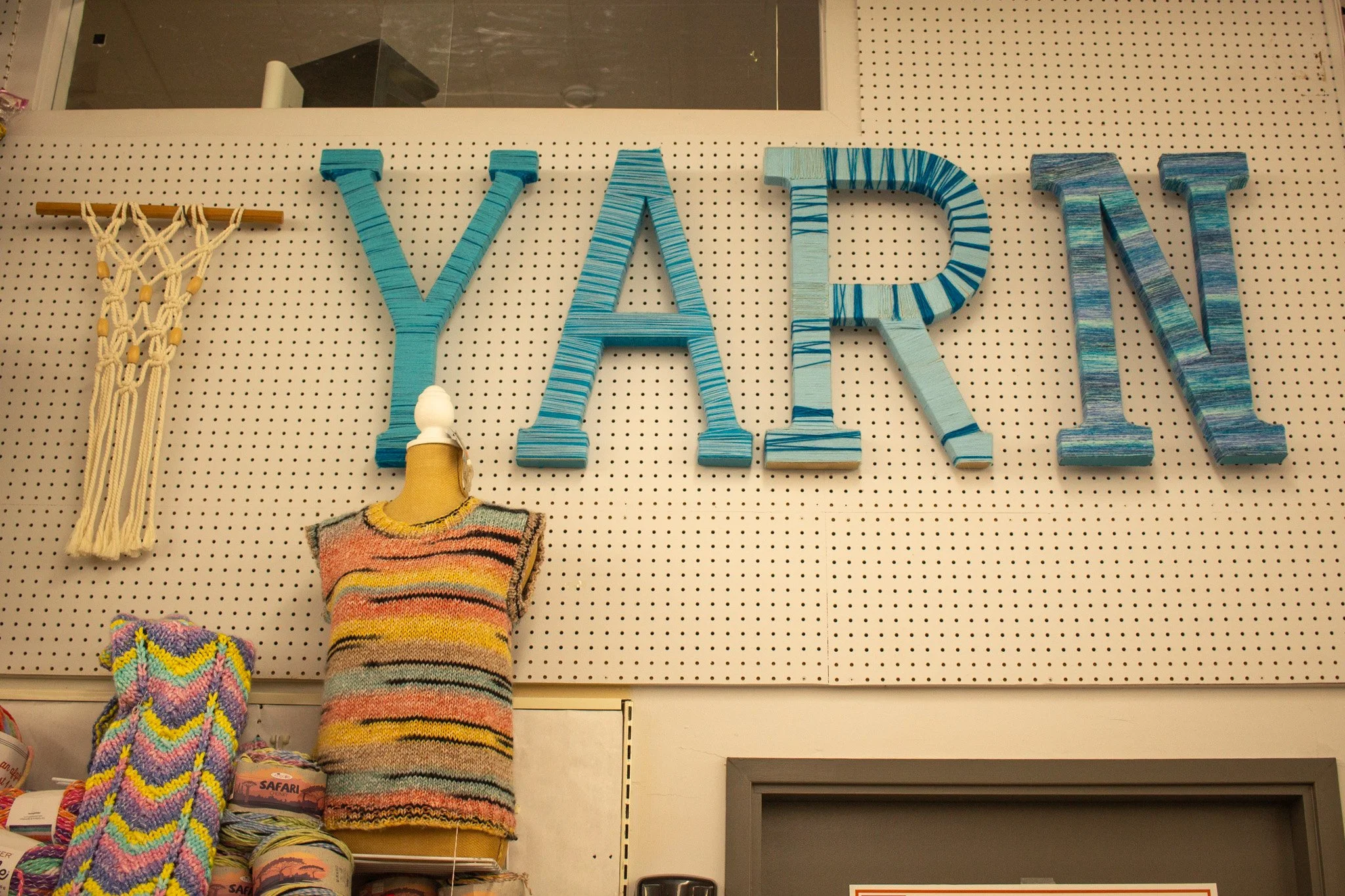 A handmade Yarn sign hangs on the wall.