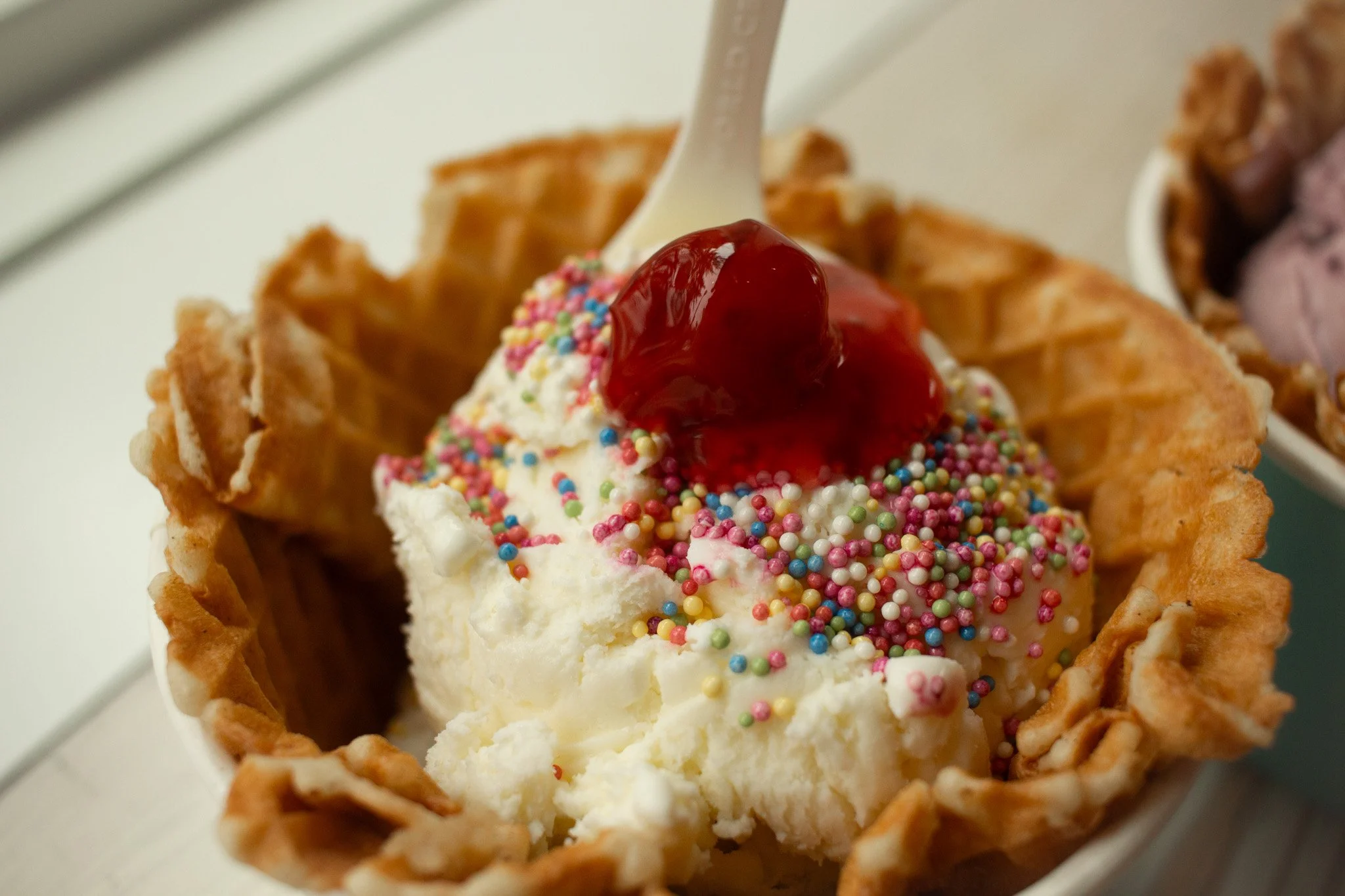 Sweet Cream ice cream, with sprinkles and a cherry. 