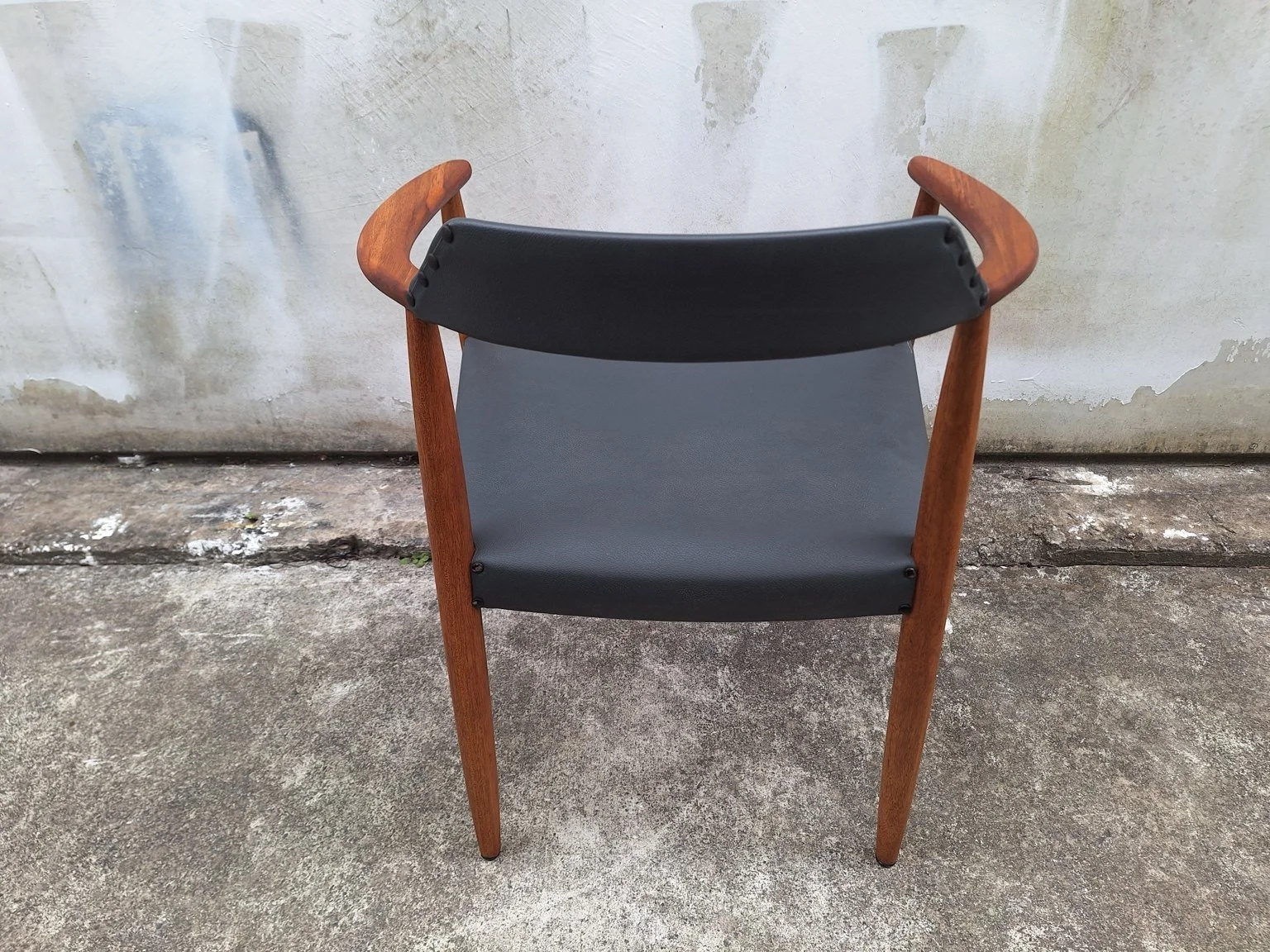 Rear view of the chair showing its upholstered backrest and seat.