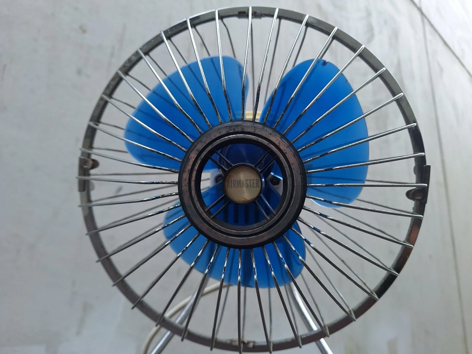 Close view of the Airmaster badge, blue blades and worn metal grille.