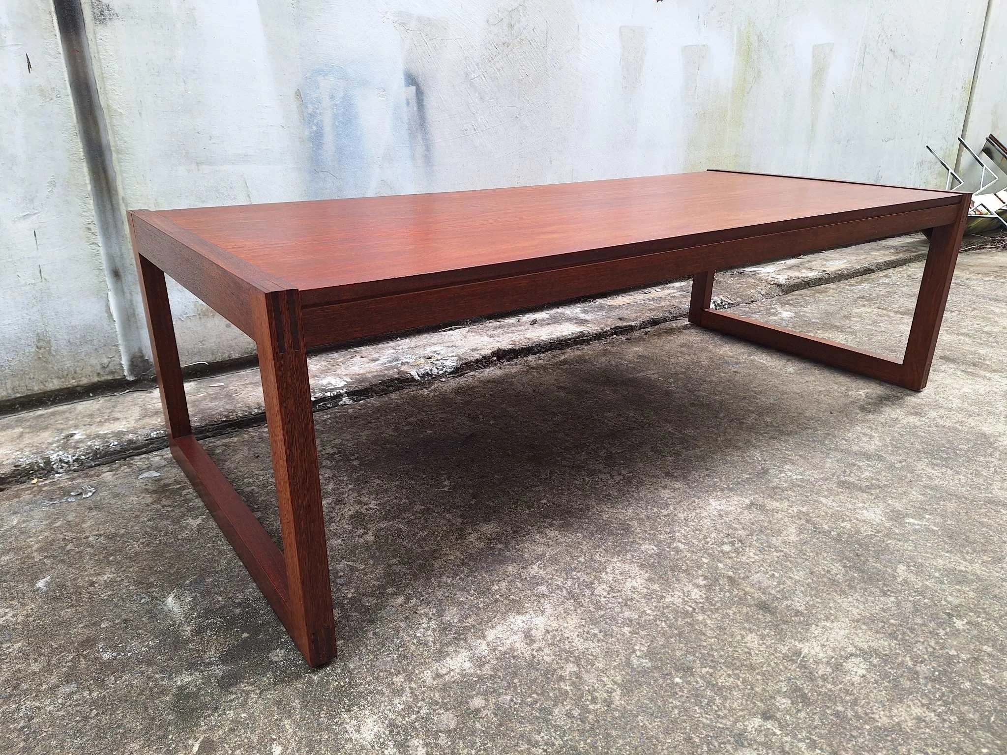 Restored mid century modern teak coffee table with architectural frame and rich teak grain.