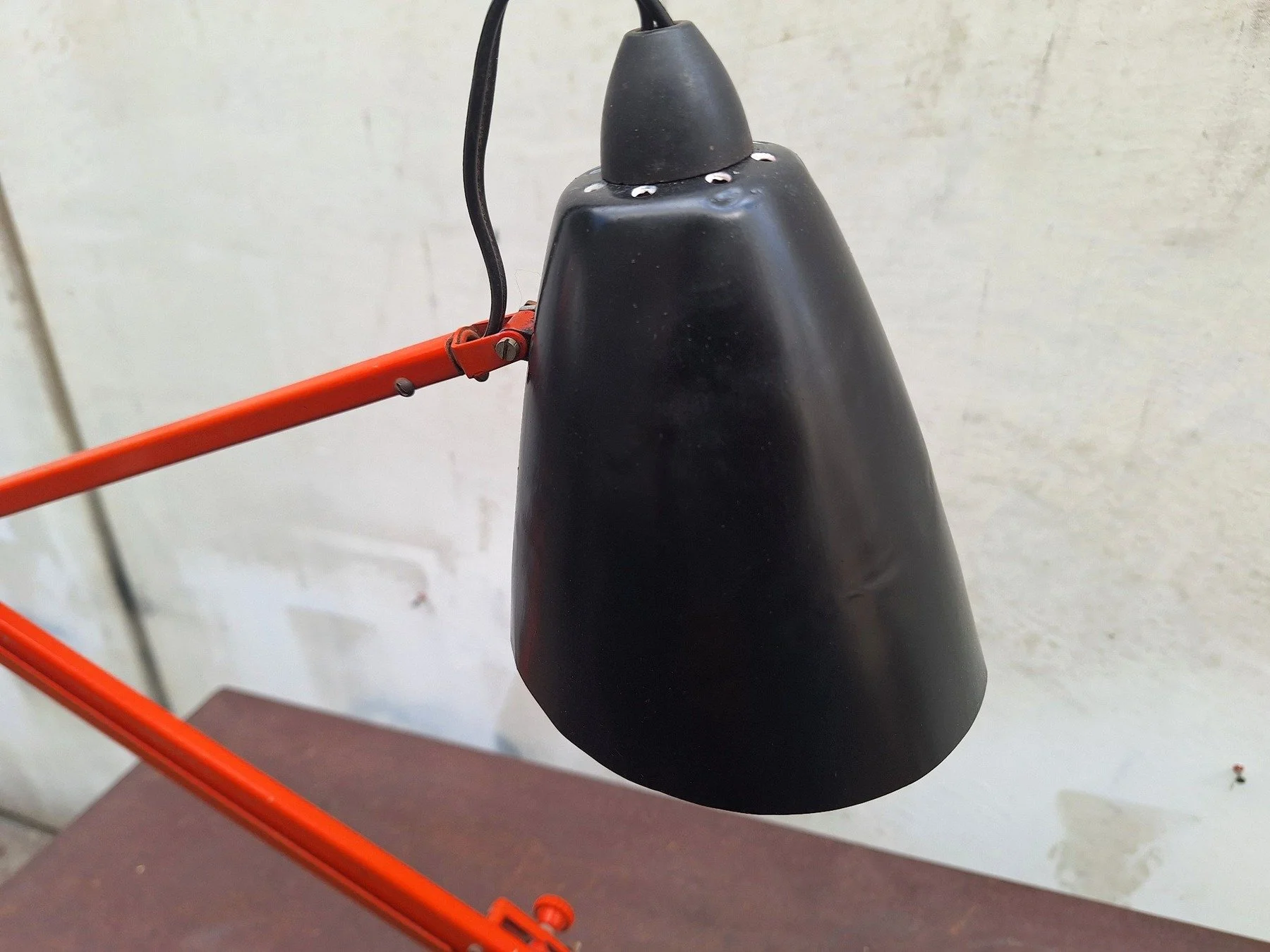 Vintage Planet Studio desk lamp with orange articulated arm, black metal shade and original Planet Products maker's label on weighted base.