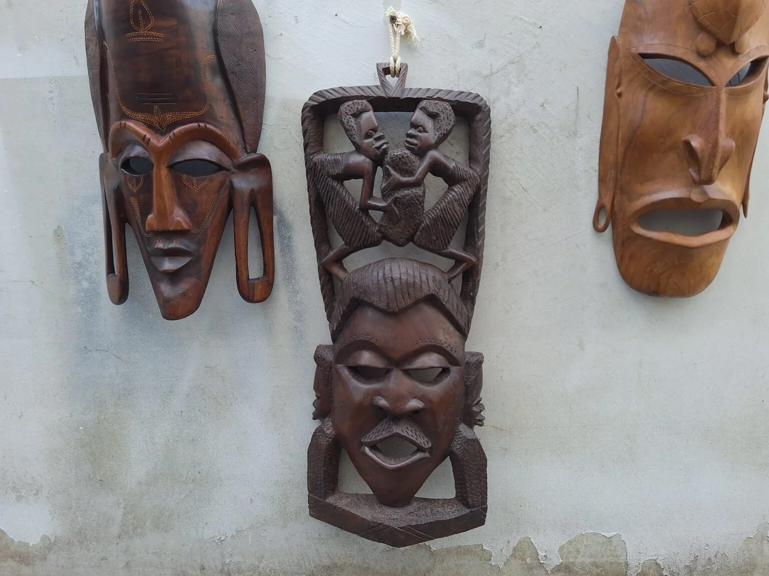 Closer view of the carved figural wall panel showing the openwork figures and facial detailing.