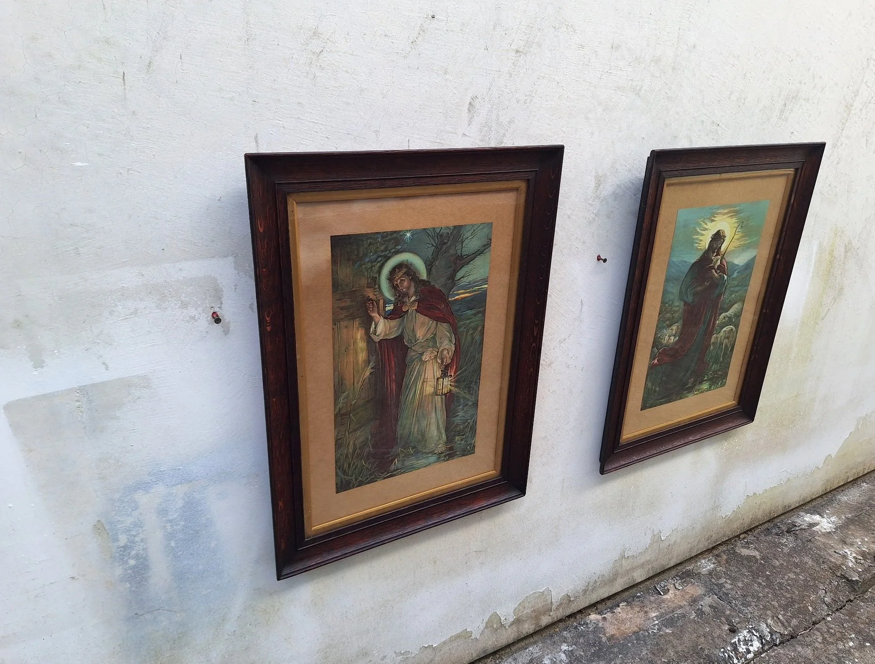 Pair of framed vintage religious prints viewed from the side