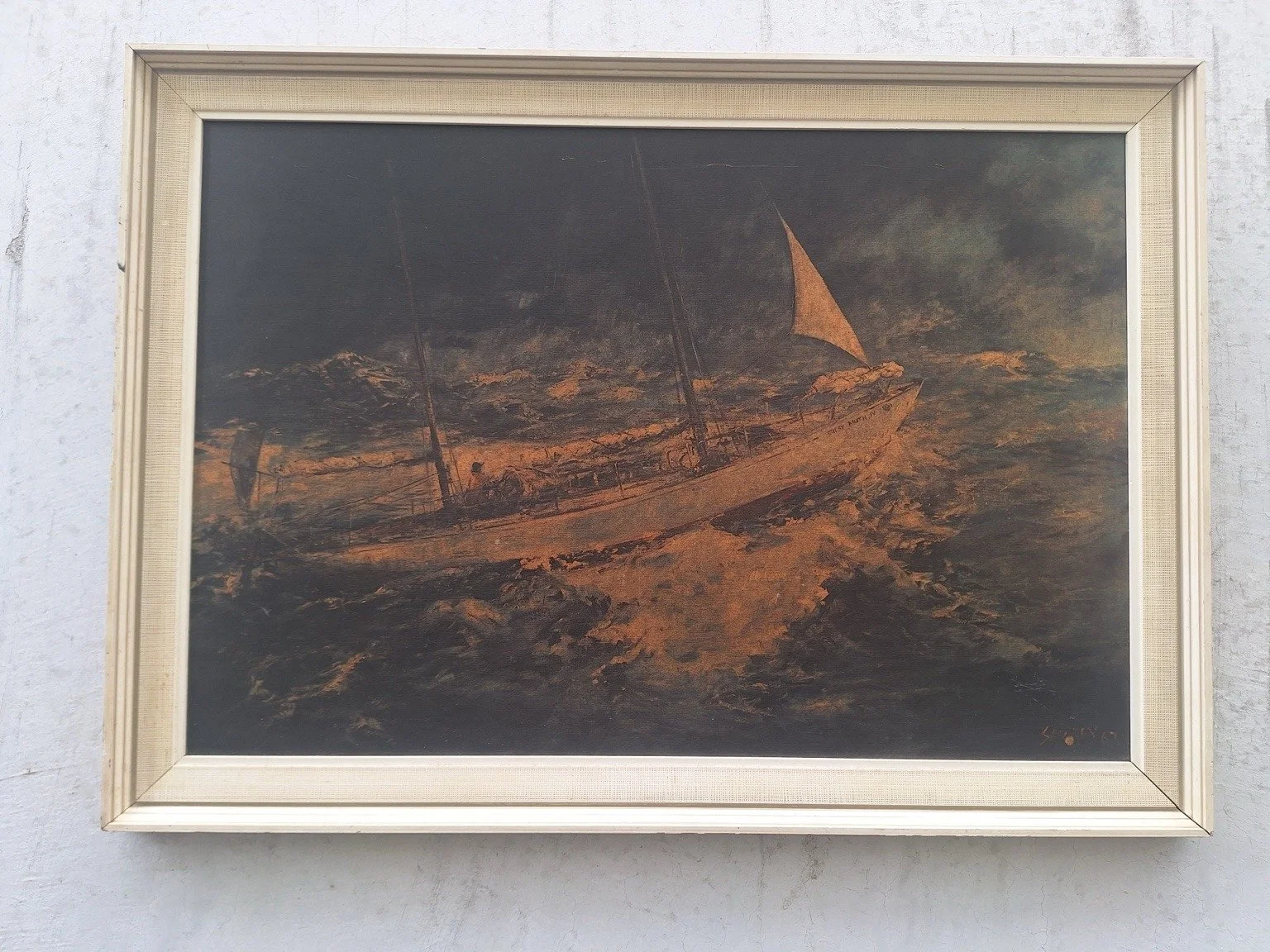 Front view of a vintage maritime print showing a ship on rough seas in a pale decorative frame.