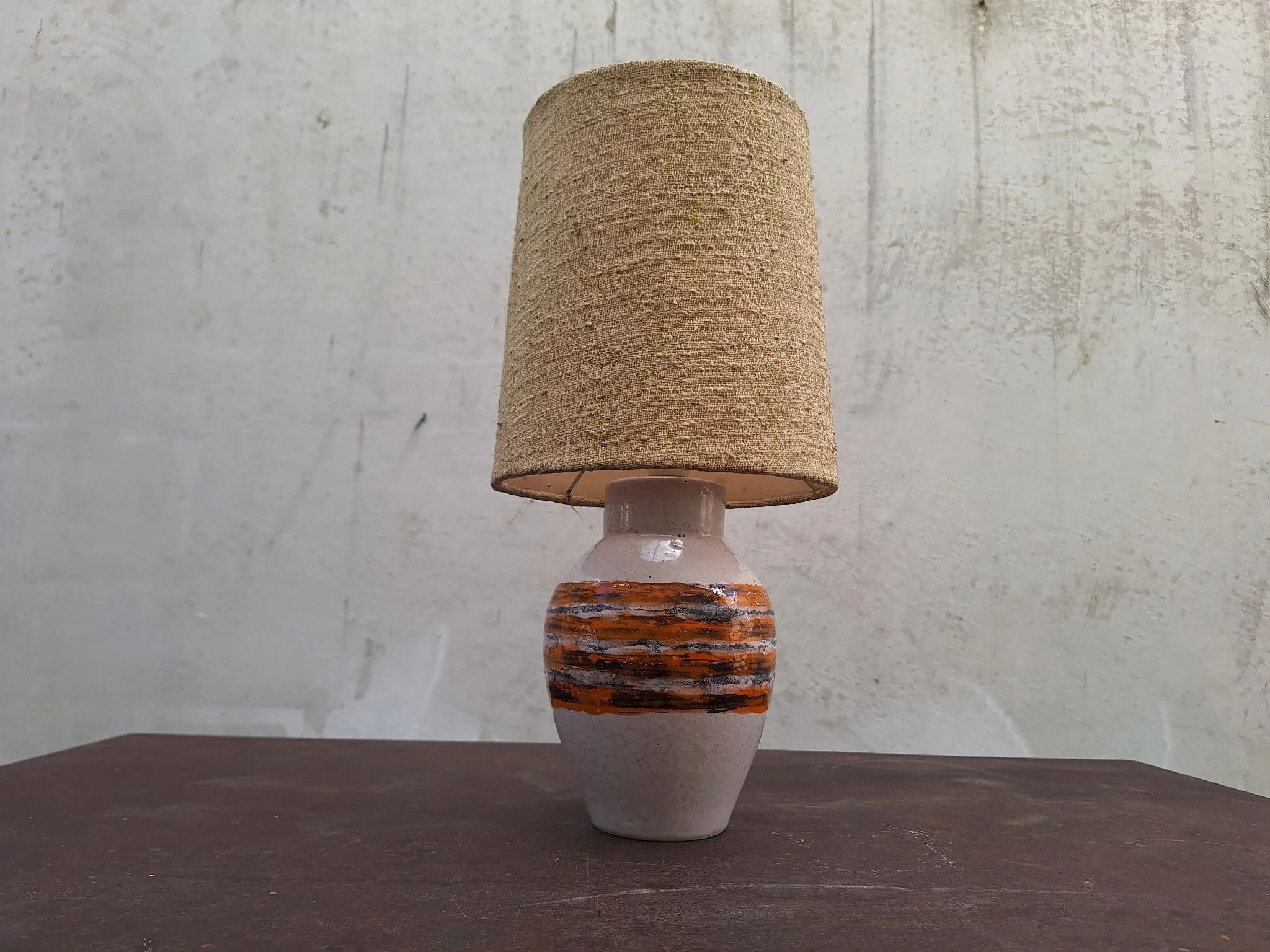 Vintage Bitossi ceramic table lamp with textured off white glaze, orange and charcoal banding, woven shade and braided cord.