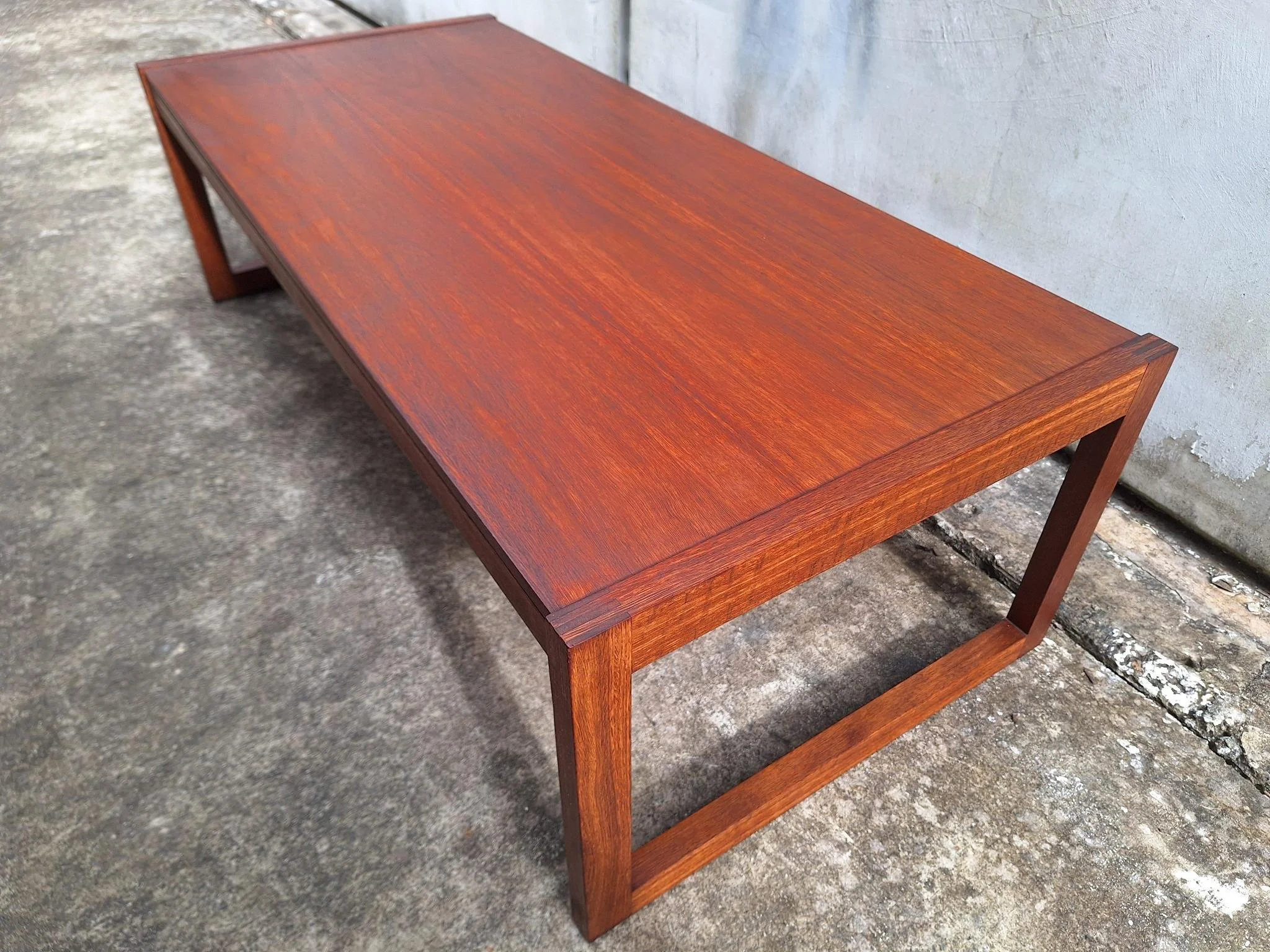 Restored mid century modern teak coffee table with architectural frame and rich teak grain.