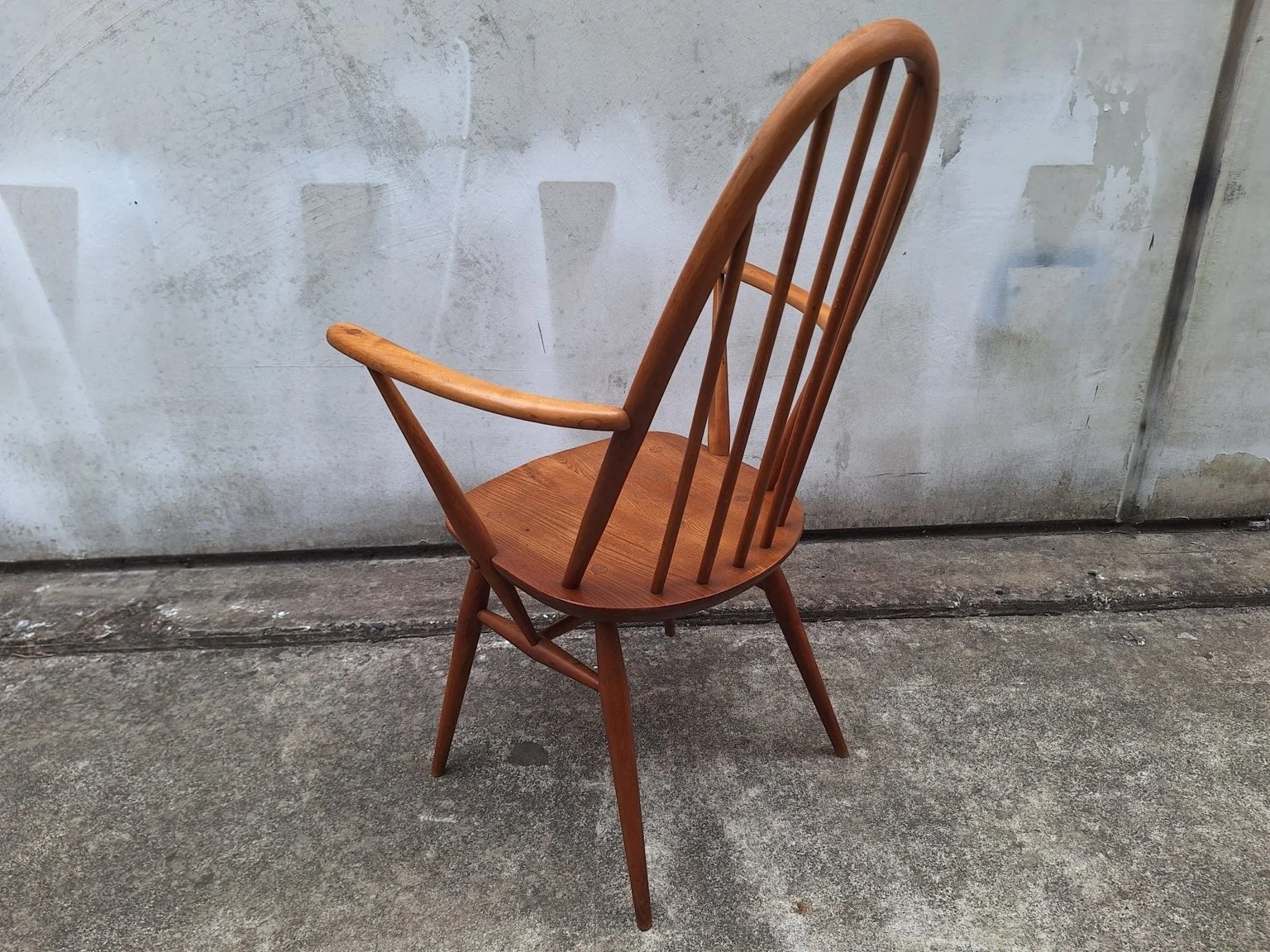 Rear angled view of the Ercol carver chair showing the spindle back and stretcher construction.