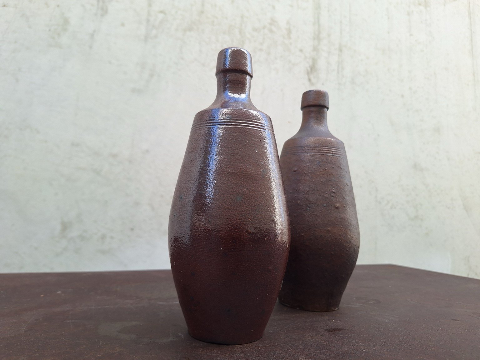 Three-quarter view of the brown glazed Portuguese ceramic bottle vases.