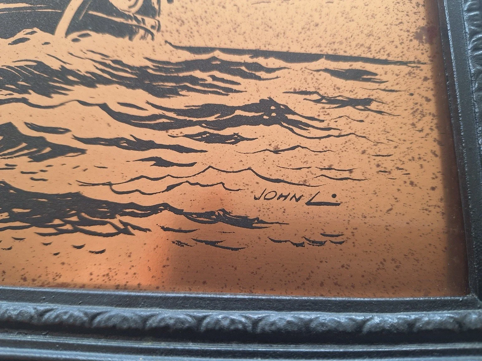 Close view of the John L. signature and mottled patina on the copper surface.