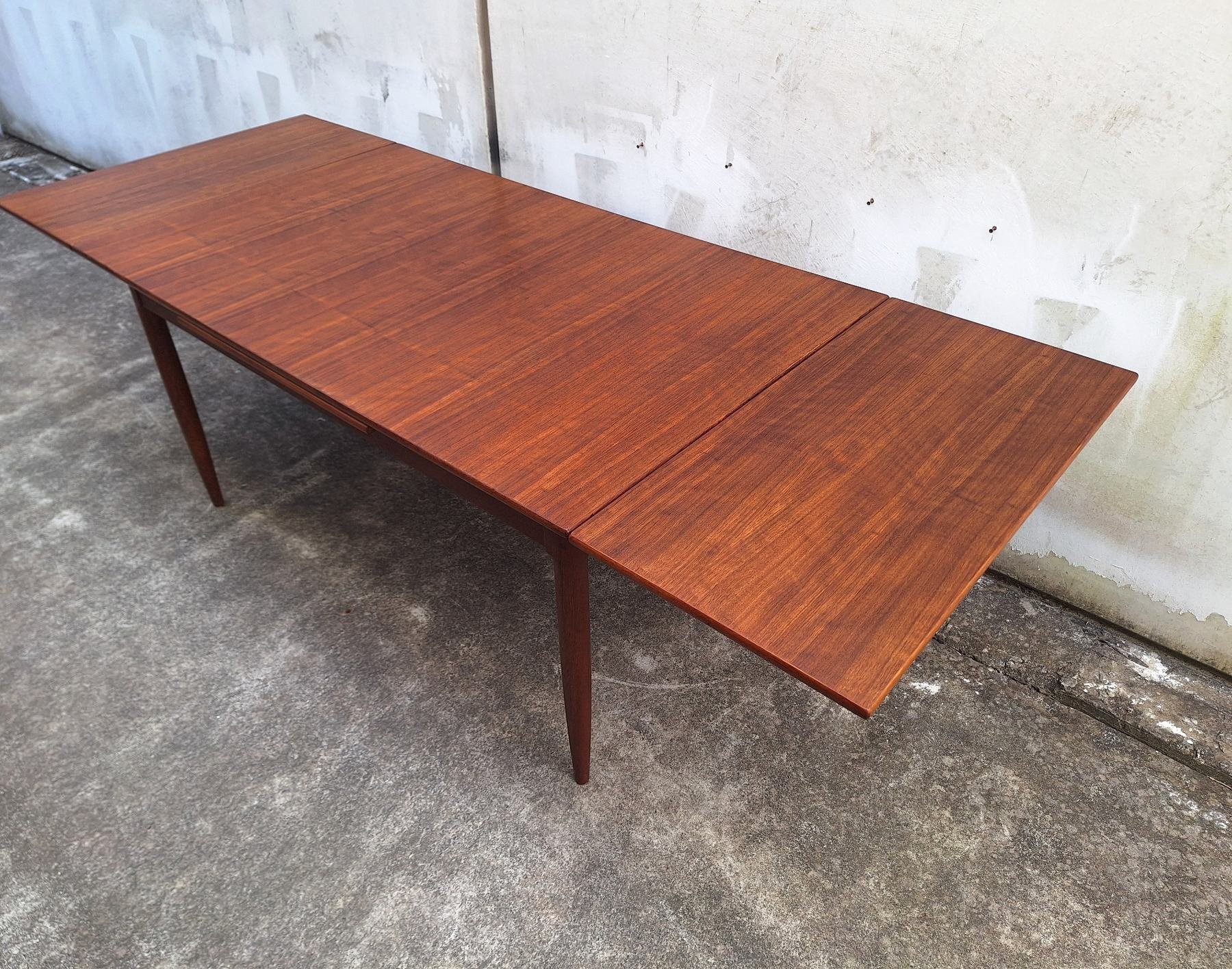 Fully extended DQF blackbean dining table seating approximately eight to ten people.