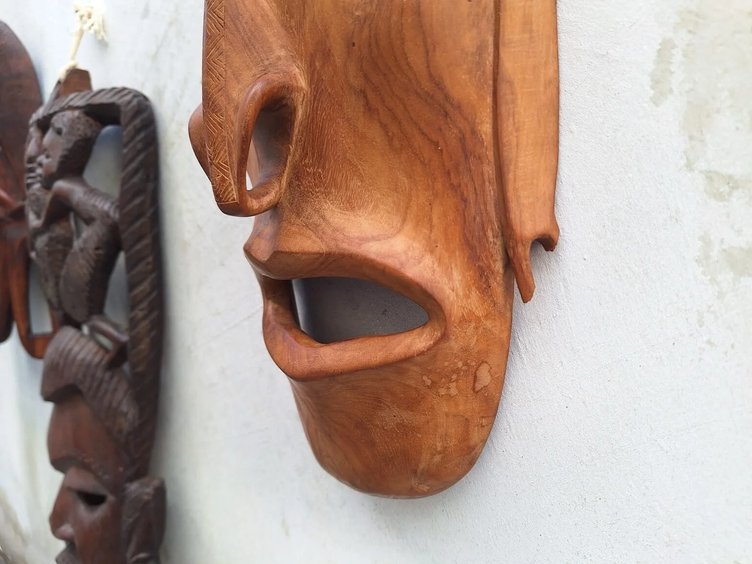 Close view of the turtle wall mask showing the open mouth, side detail and broken ear.