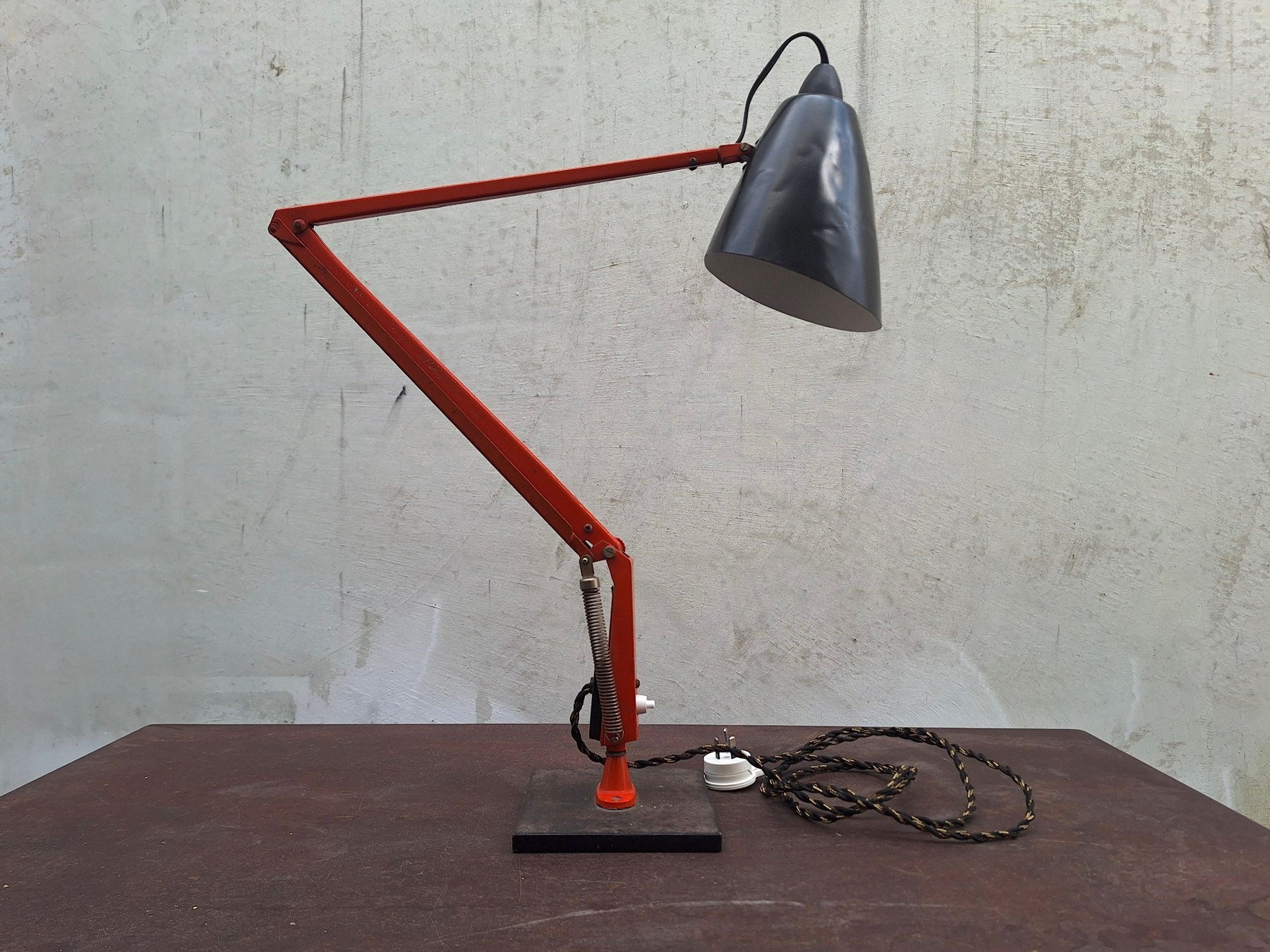 Vintage Planet Studio desk lamp with orange articulated arm, black metal shade and original Planet Products maker's label on weighted base.