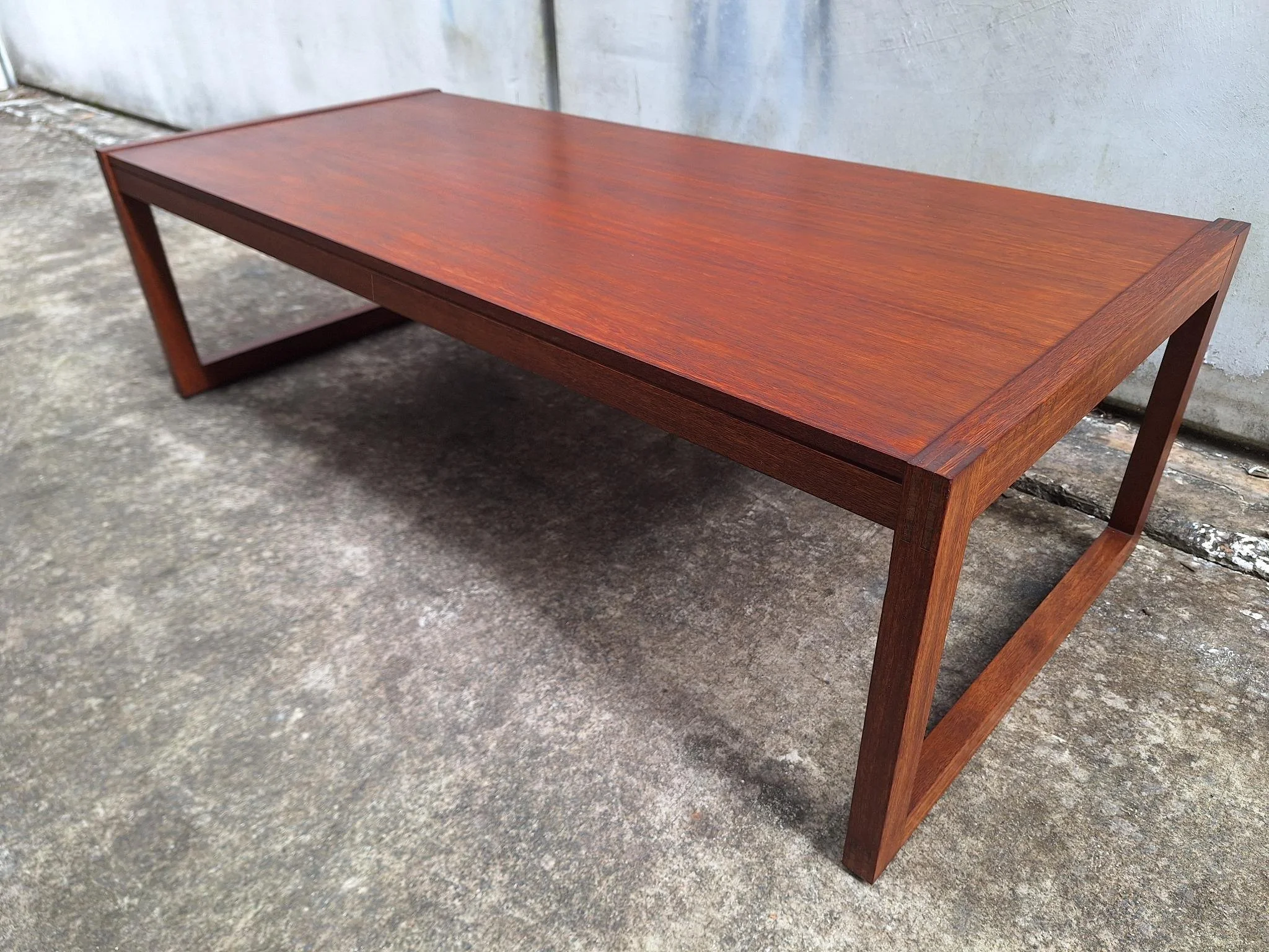Restored mid century modern teak coffee table with architectural frame and rich teak grain.