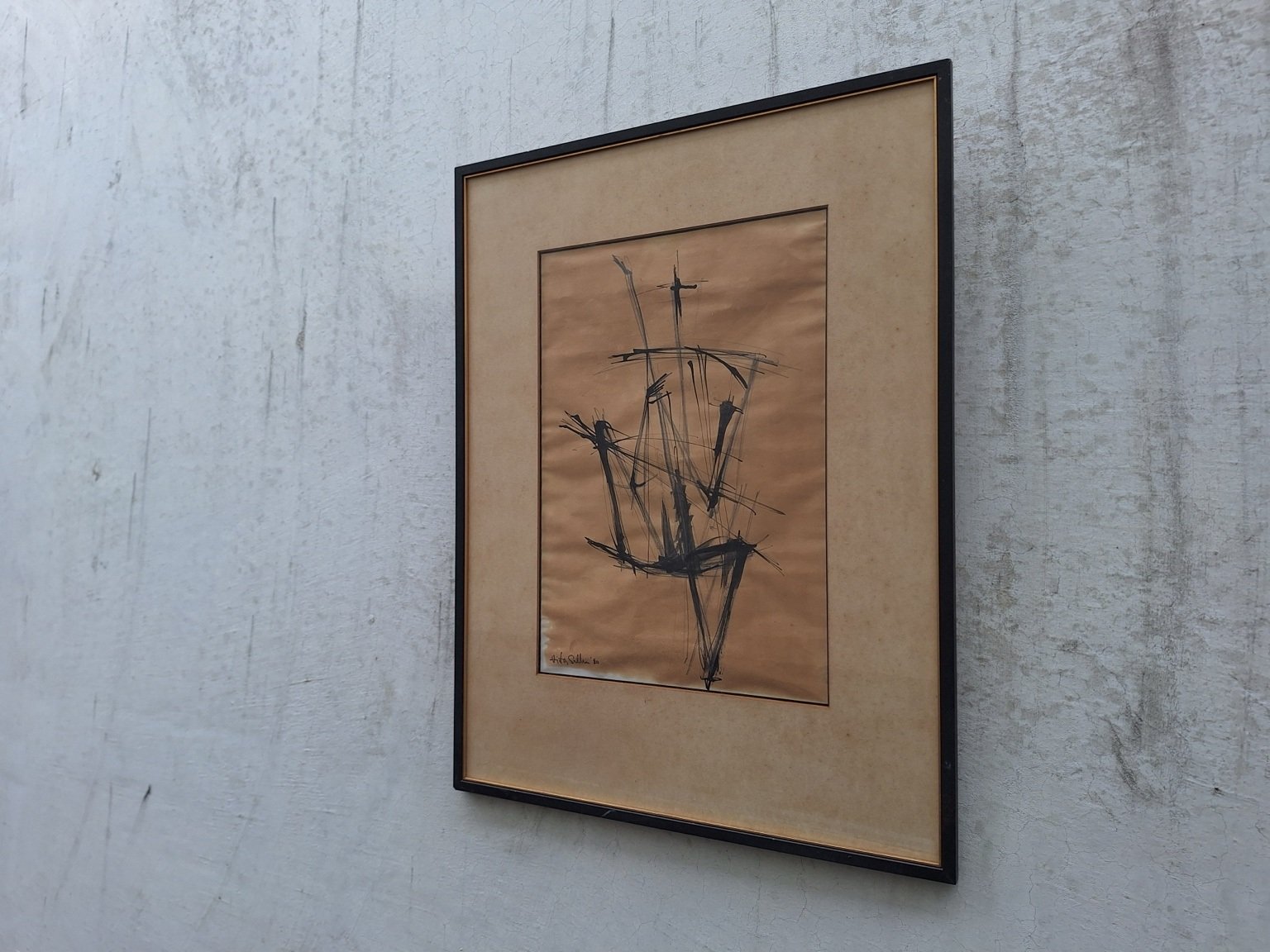 Angled view showing the abstract composition, broad tan mount and black frame.