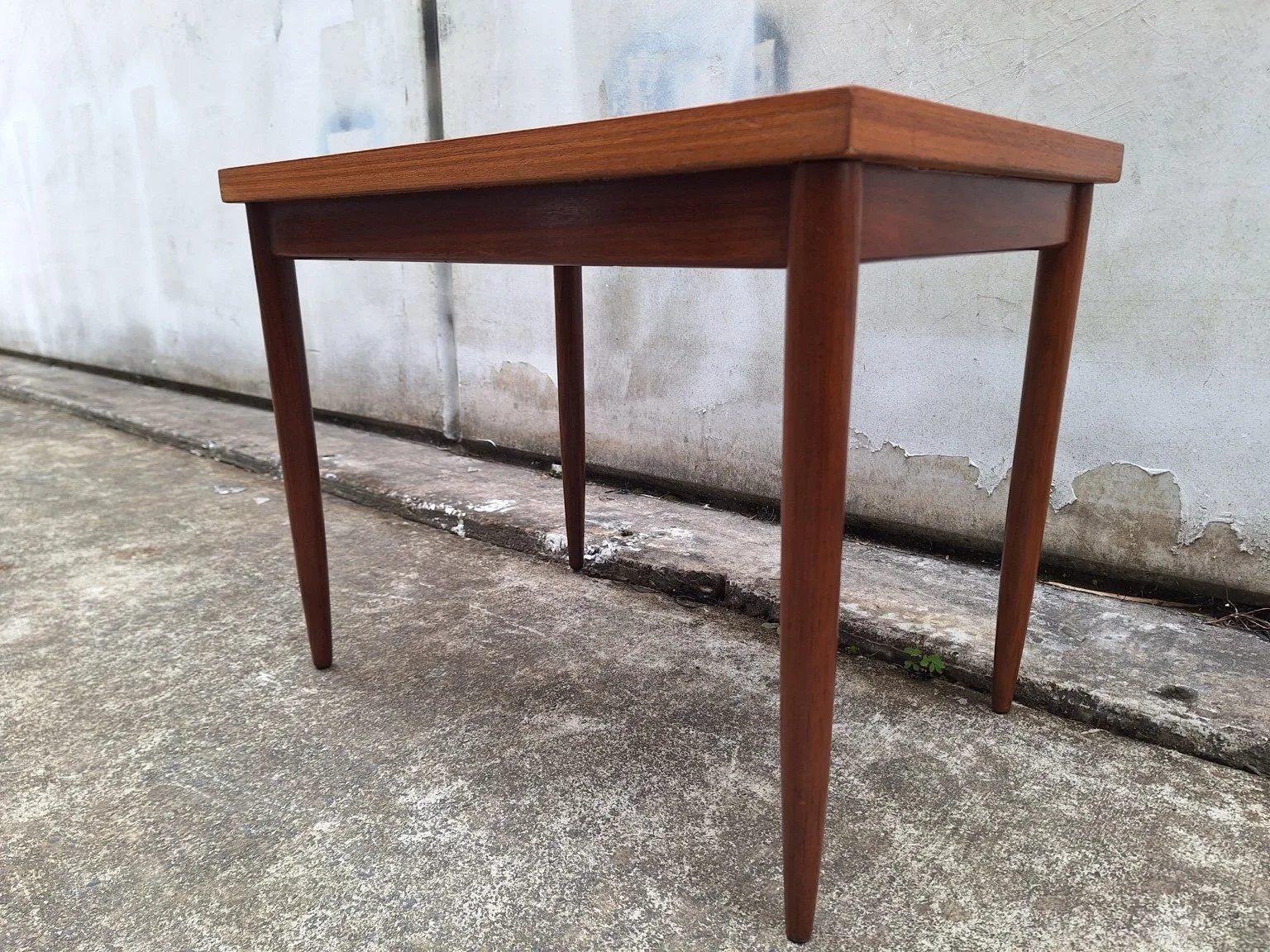Low view showing the apron and tapered legs beneath the veneered top.
