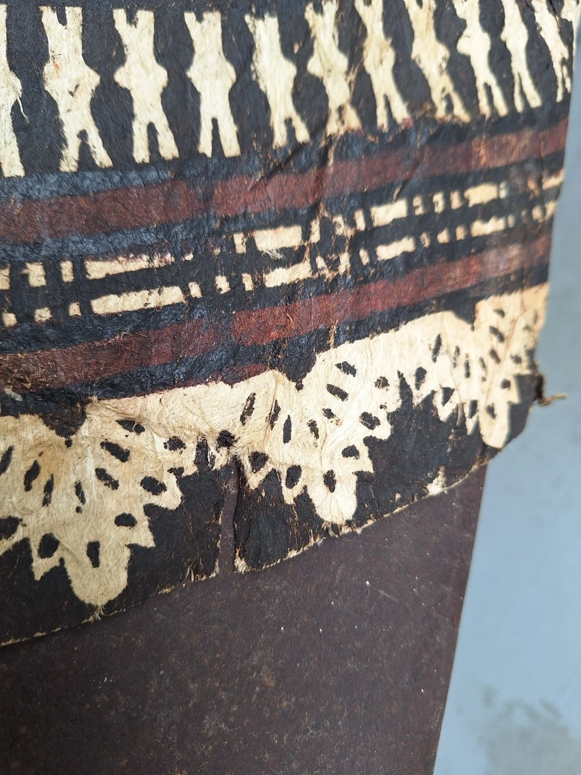 Close view of splits, creasing and fibre wear across the black, cream and reddish-brown outer border.