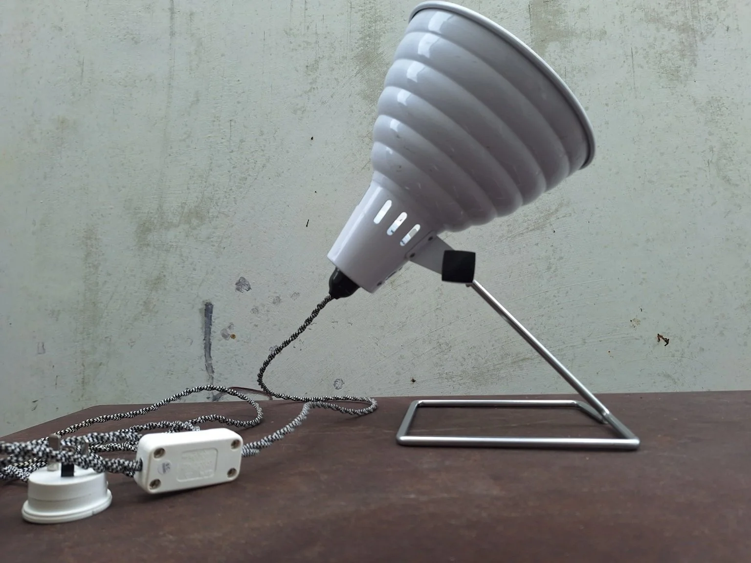 Pifco lamp tilted upward on its wire stand.