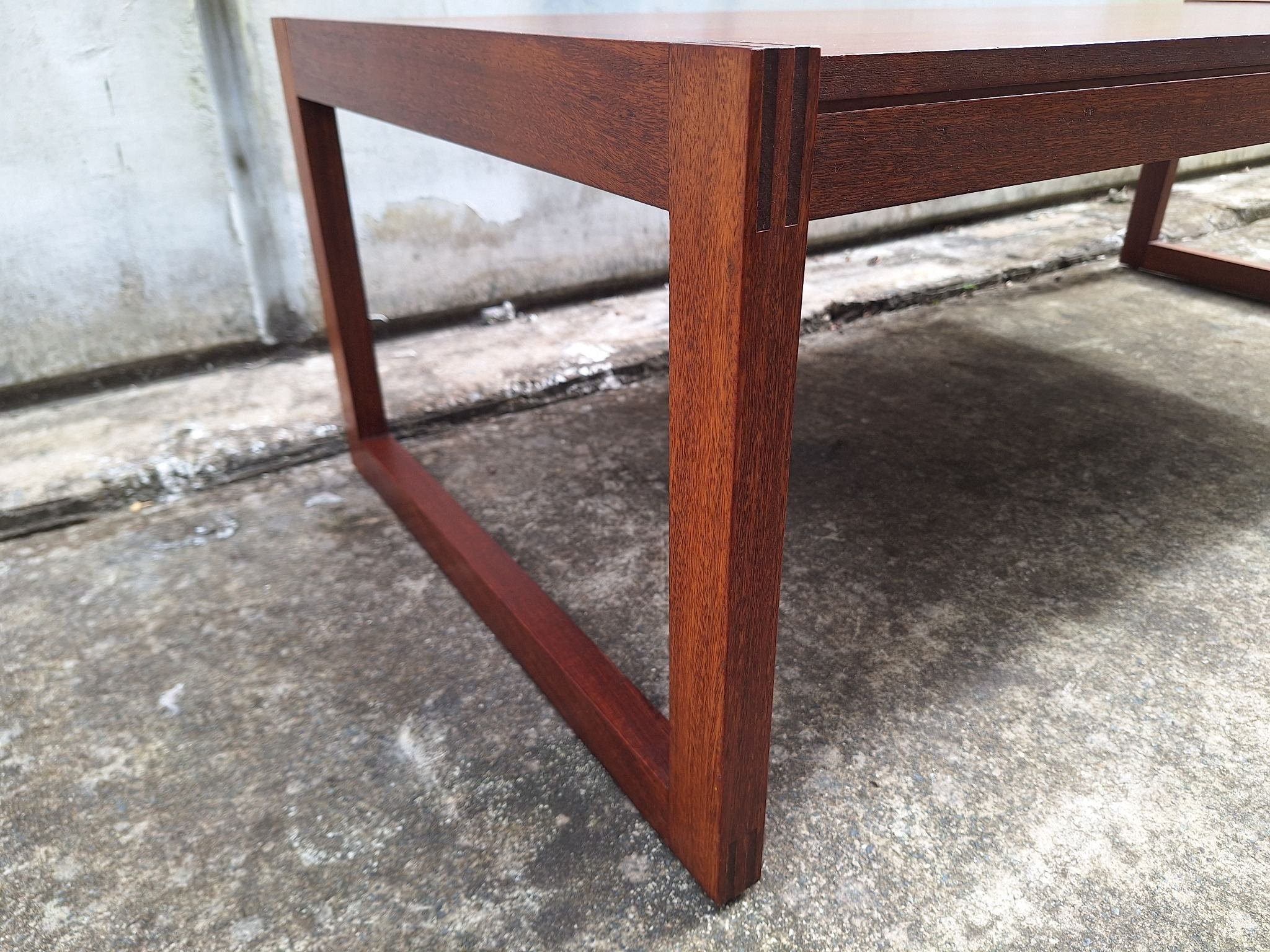 Restored mid century modern teak coffee table with architectural frame and rich teak grain.