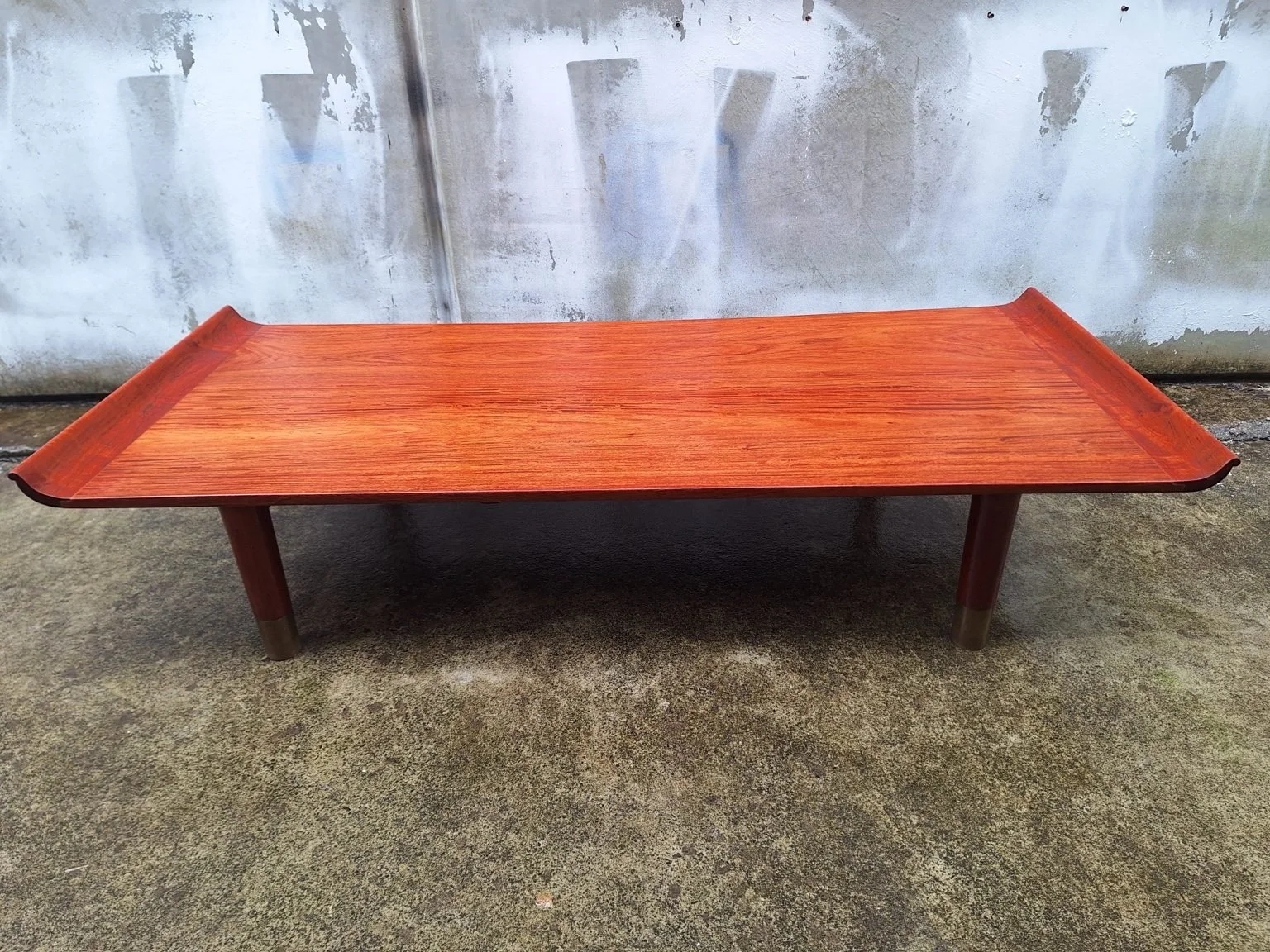 Front view showing the long rosewood tabletop and raised lips at both ends.