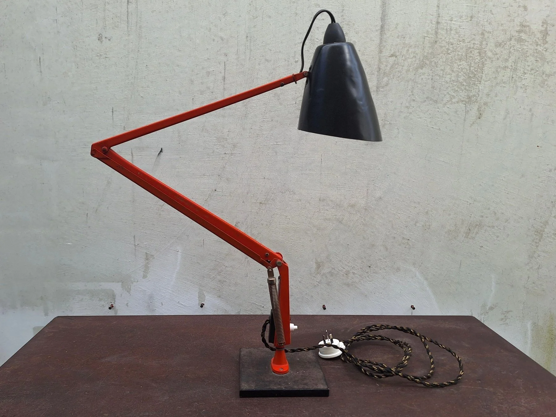 Vintage Planet Studio desk lamp with orange articulated arm, black metal shade and original Planet Products maker's label on weighted base.