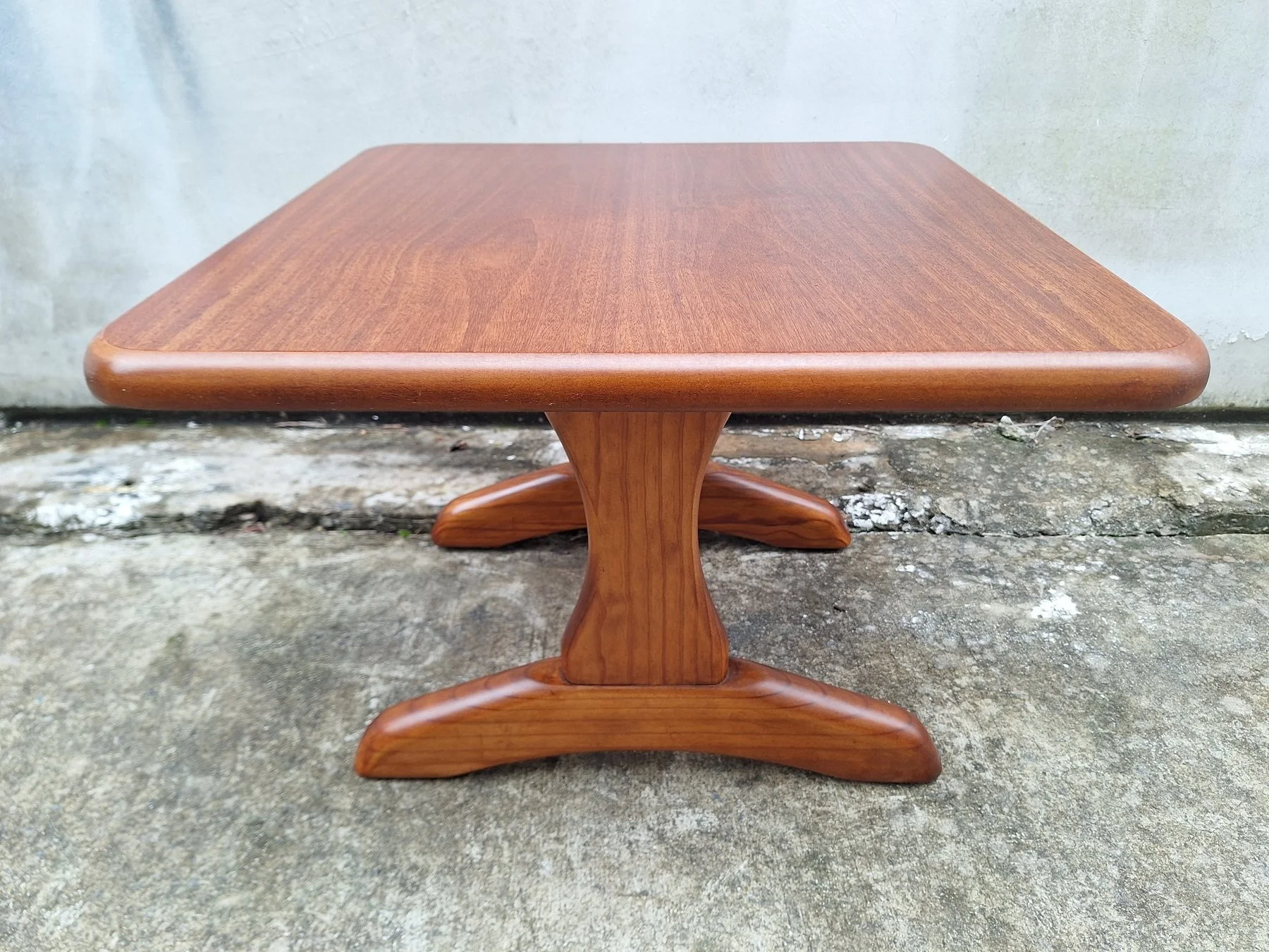 Vintage square timber coffee table with rounded edges and sculptural pedestal base.