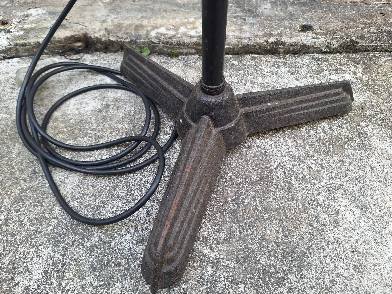 Three-foot base and coiled power cable of lamp No. 1, showing surface wear.