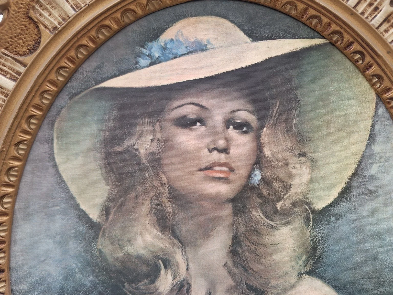 Detail of the printed portrait showing the woman’s face, wide-brimmed hat and blue floral trim.